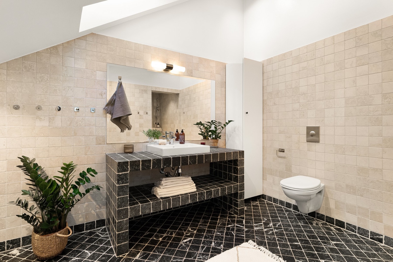 Tidløst og meget romslig baderom fra 2004. Badet er innredet plassbygget servantskap med flislagte hyller, speil, belysning, toalett og dusjnisje. Galleribilde