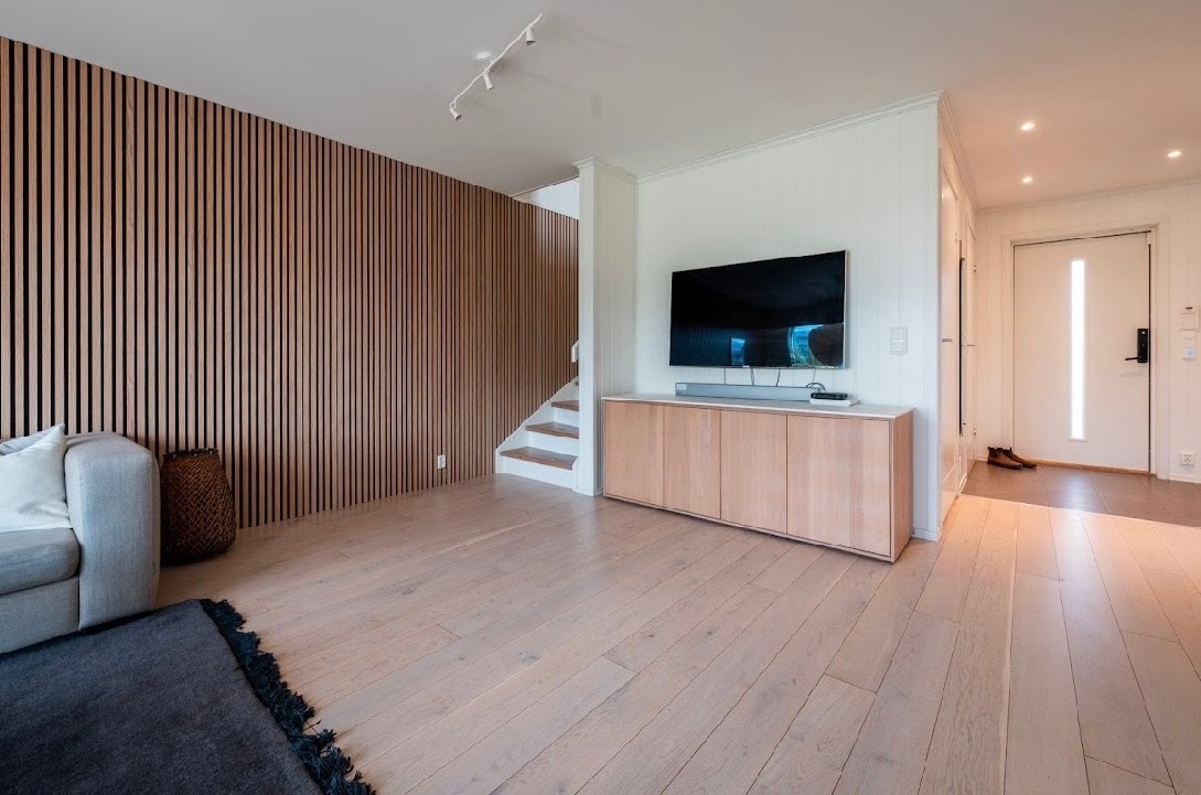 Den varme atmosfæren følger oss ned til 1. etasje med en moderne og tidløs spilevegg. Galleribilde