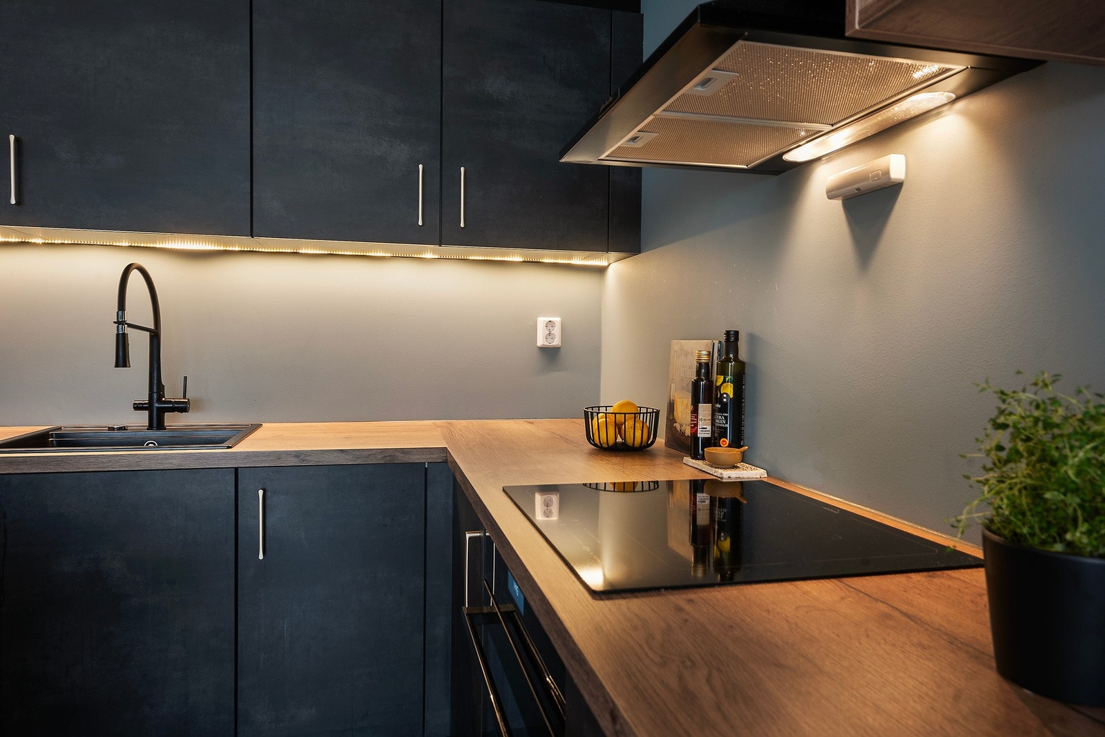 Innredningen er takoppforet med mørke, glatte fronter, eikefarget hylle og vitrineskap med belysning Galleribilde