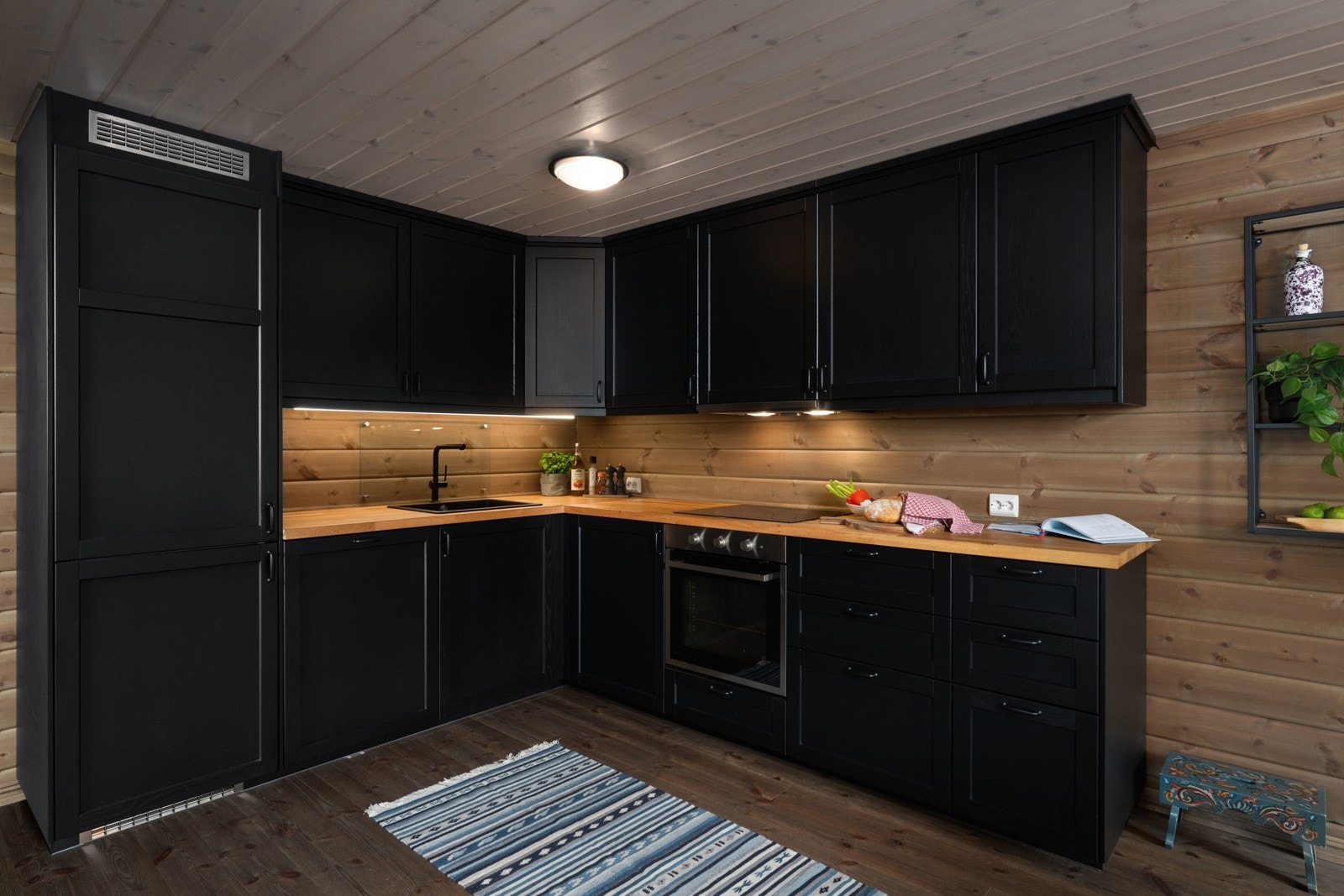 Moderne L-kjøkken med stilfulle profilerte fronter malt i svart. Godt med lagringsplass i form av over- og underskap. Galleribilde