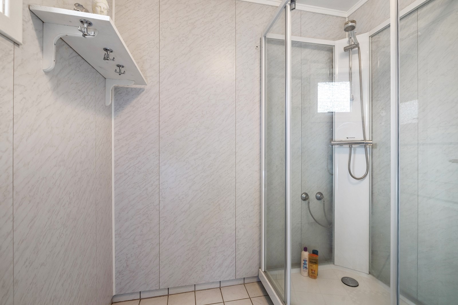 Badet inneholder servantinnredning med høyskap, toalett og dusjkabinett. Galleribilde