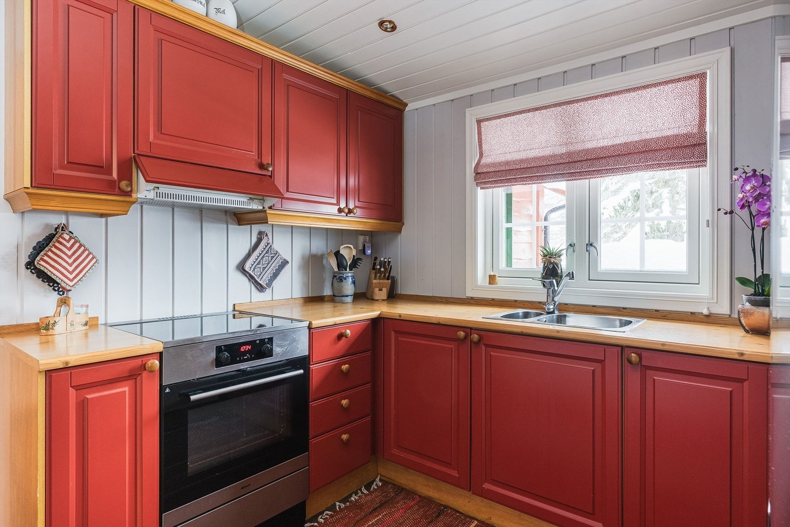 Velholdt og pen kjøkkeninnredning med profilerte fronter og laminert benkeplate med nedfelt oppvaskkum. Plass til frittstående komfyr og kjøleskap med frysedel. Ventilator med mekanisk vifte. Galleribilde