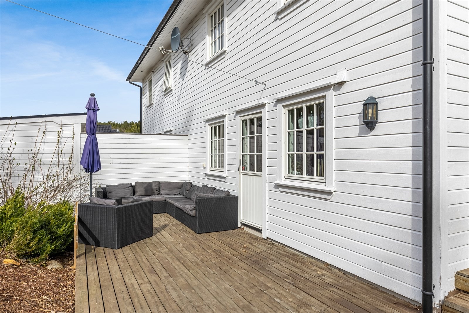 Usjenert uteområde på baksiden av boligen med plass til sittegruppe Galleribilde