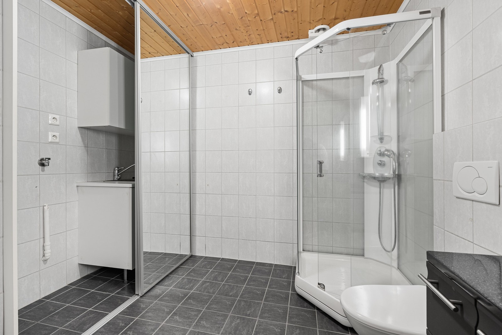 Praktiske skyvedører som skjuler opplegg for vaskemaskin og tørketrommel. I nisjen finner man også utslagsvask samt praktisk skap innredning for vaskemidler mm. Galleribilde