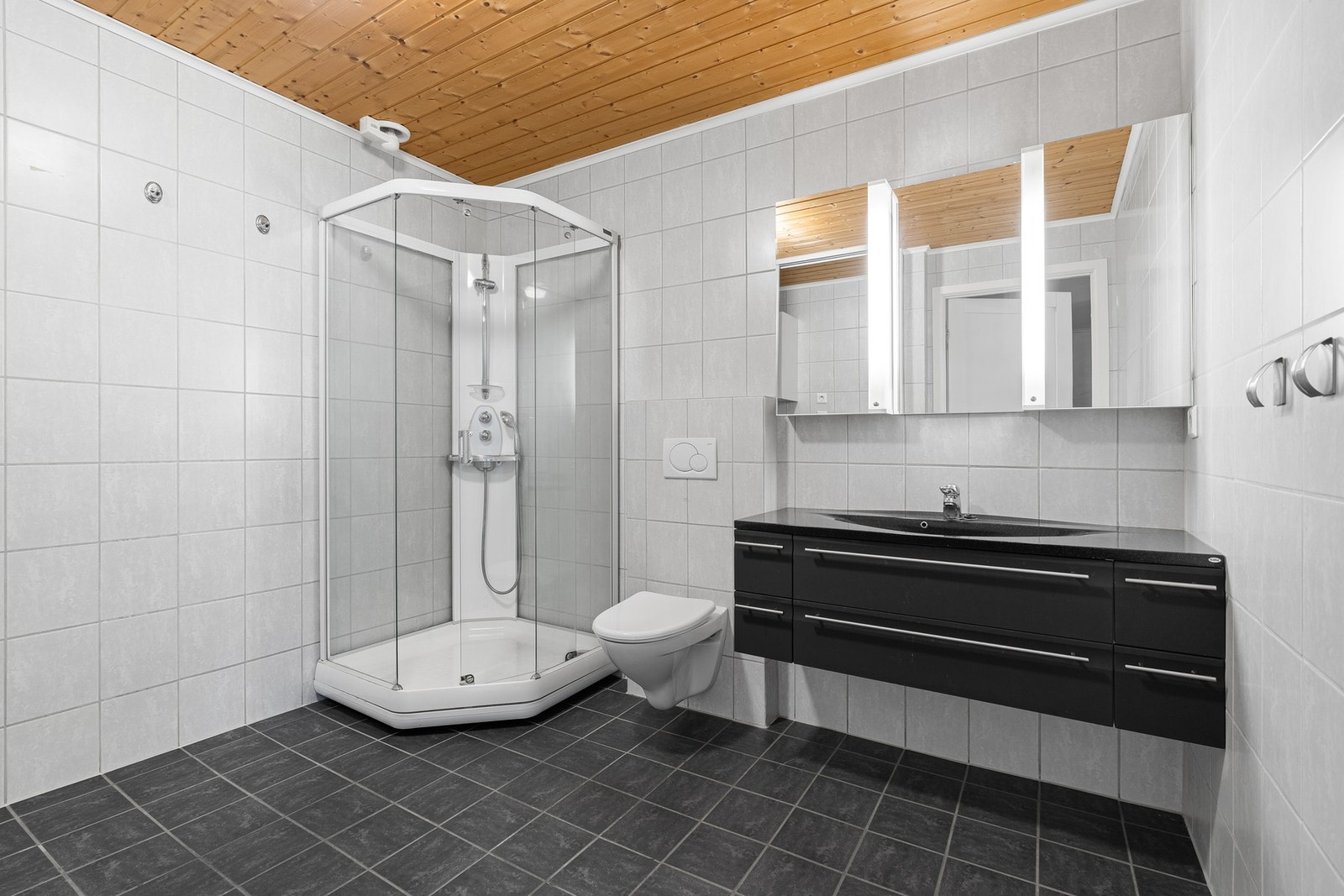 Badet er tidløst innredet med fliser og varme i gulvet. Galleribilde