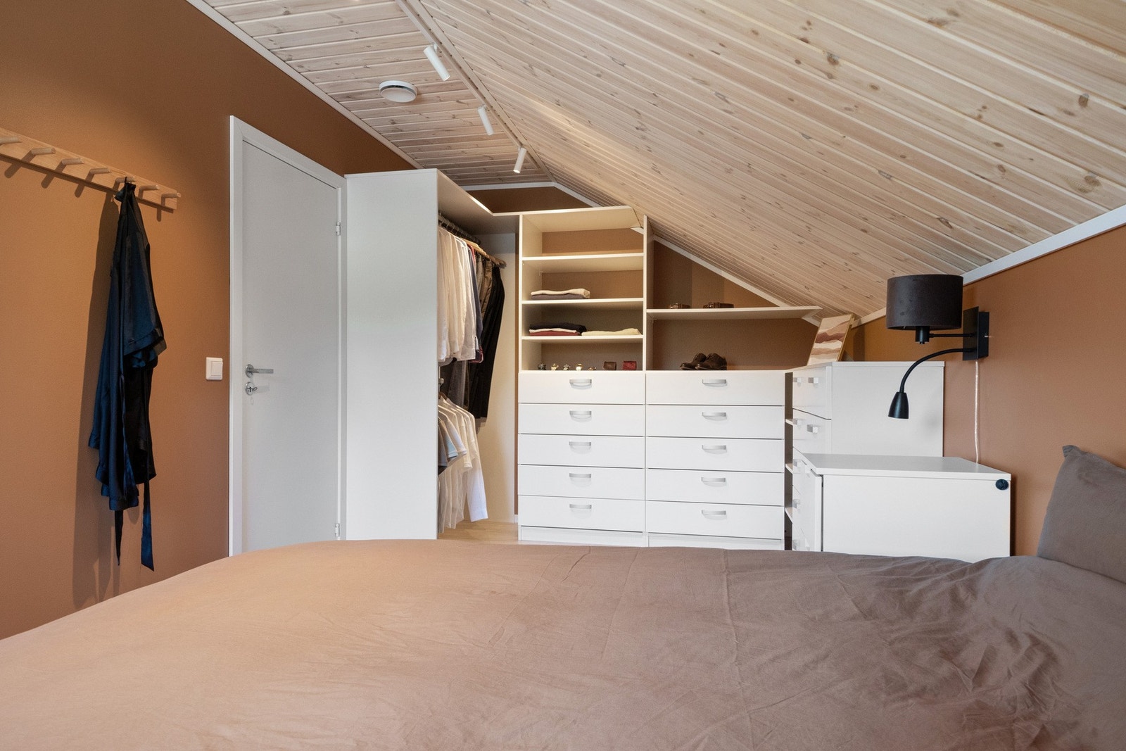 Her er det mye garderobeplass i form av skuffer, hyller og åpne stammer med klesheng. Galleribilde