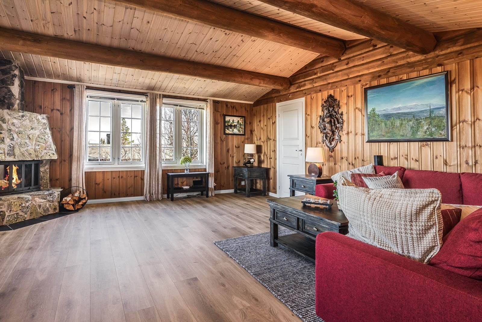 Flere store vindusflater og god takhøyde bidrar til en god og luftig romfølelse. I hjørnet av stuen er det en flott murt peis med naturstein og peisinnsats som både gir god varme og bidrar til ekstra hygge. Galleribilde