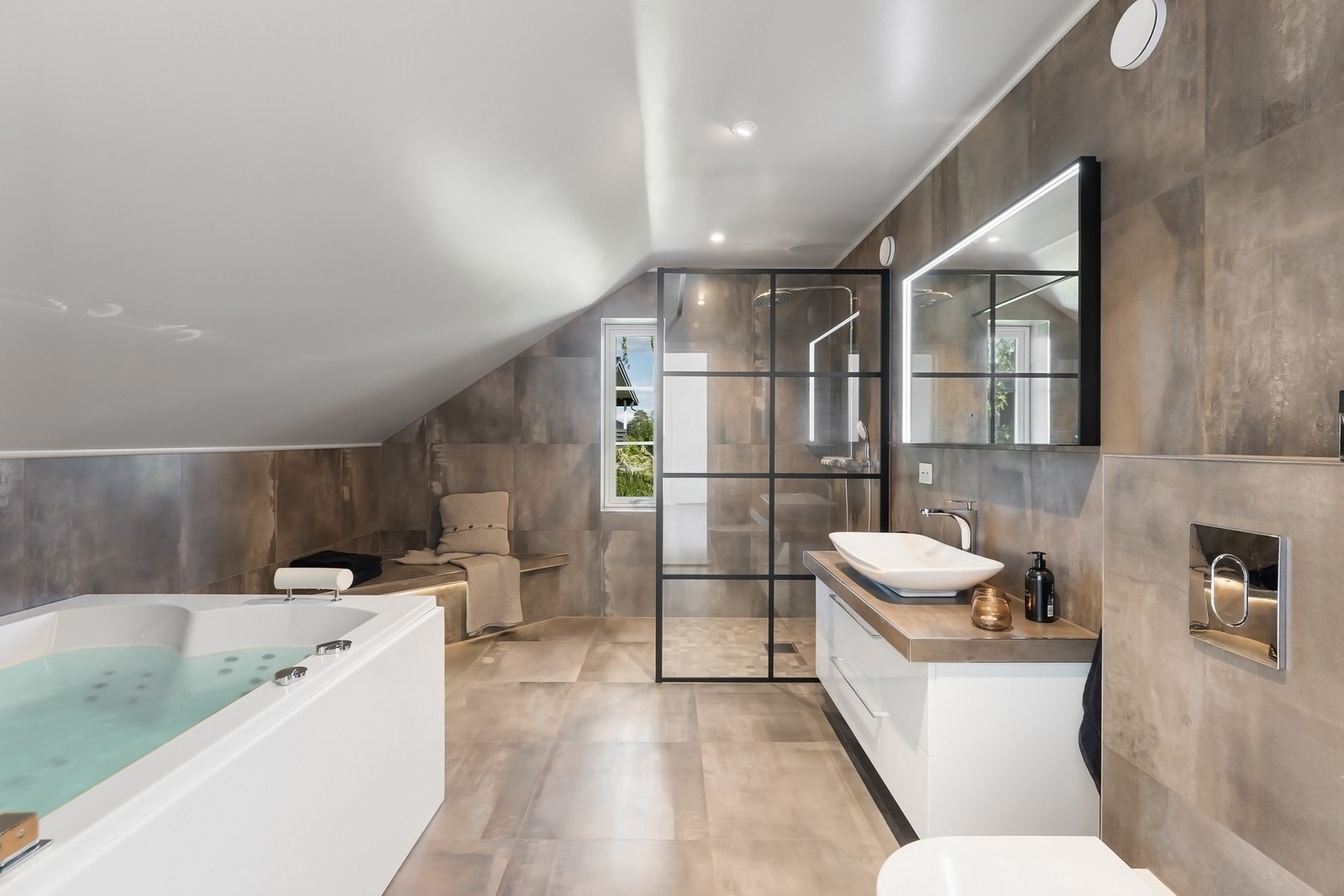 Badet er innredet med stort boblebadekar og dusj med lekker glassvegg og regnfallsdusj. Galleribilde