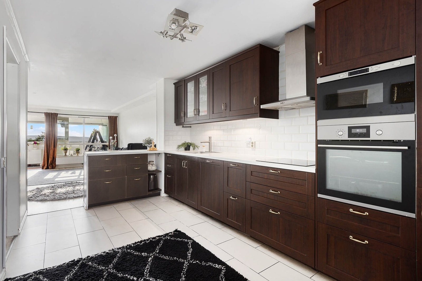 Her er kjøkkenet smart plassert i et eget hjørne som skaper et naturlig skille mellom oppholdsrom og matlagingssonen, samtidig som det åpner for sosialt samvær på tvers av rommet. Galleribilde