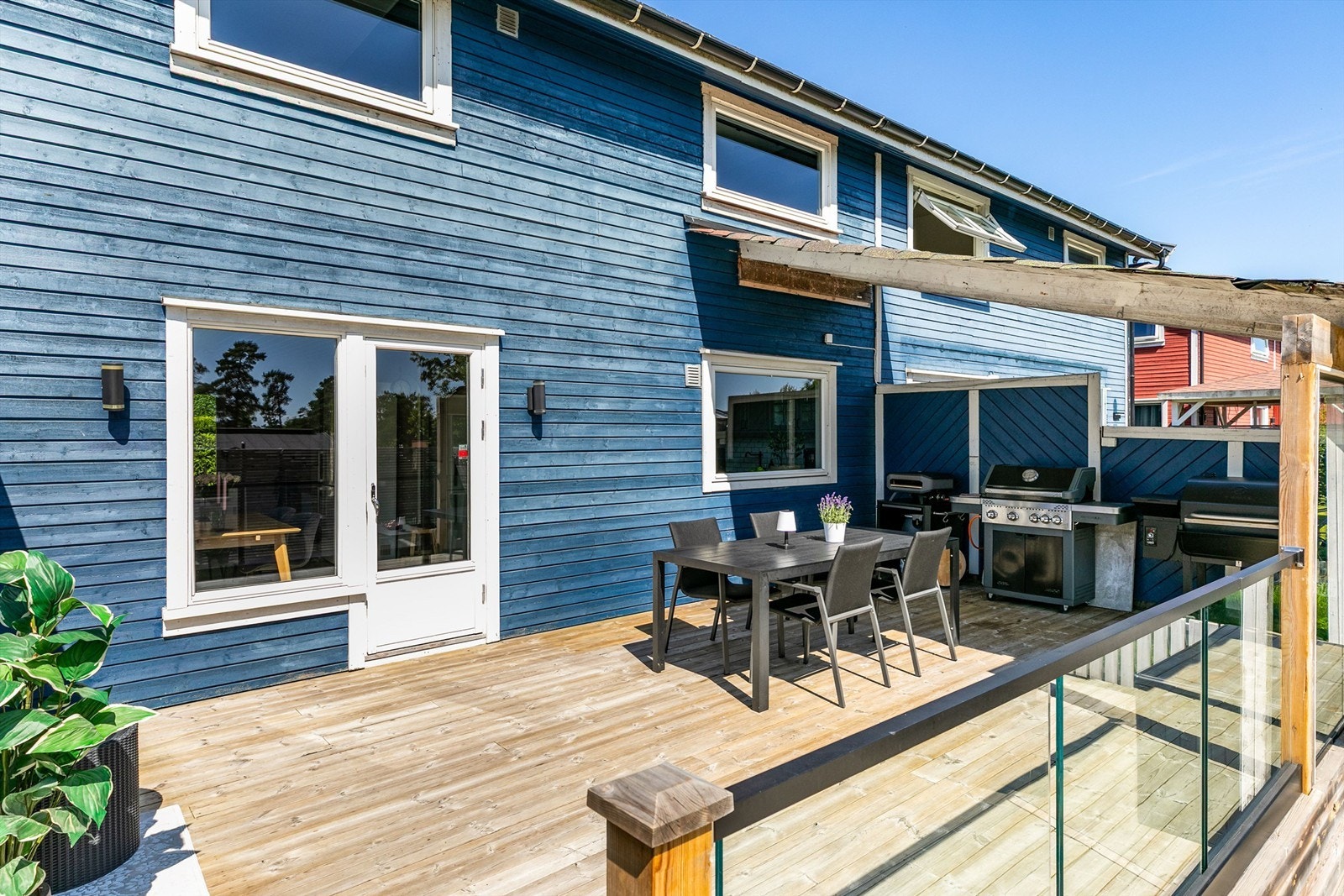 Et langstrakt spisebord har sin naturlige plass på den øvre terrassen, som også kan passe perfekt for et utekjøkken. Galleribilde