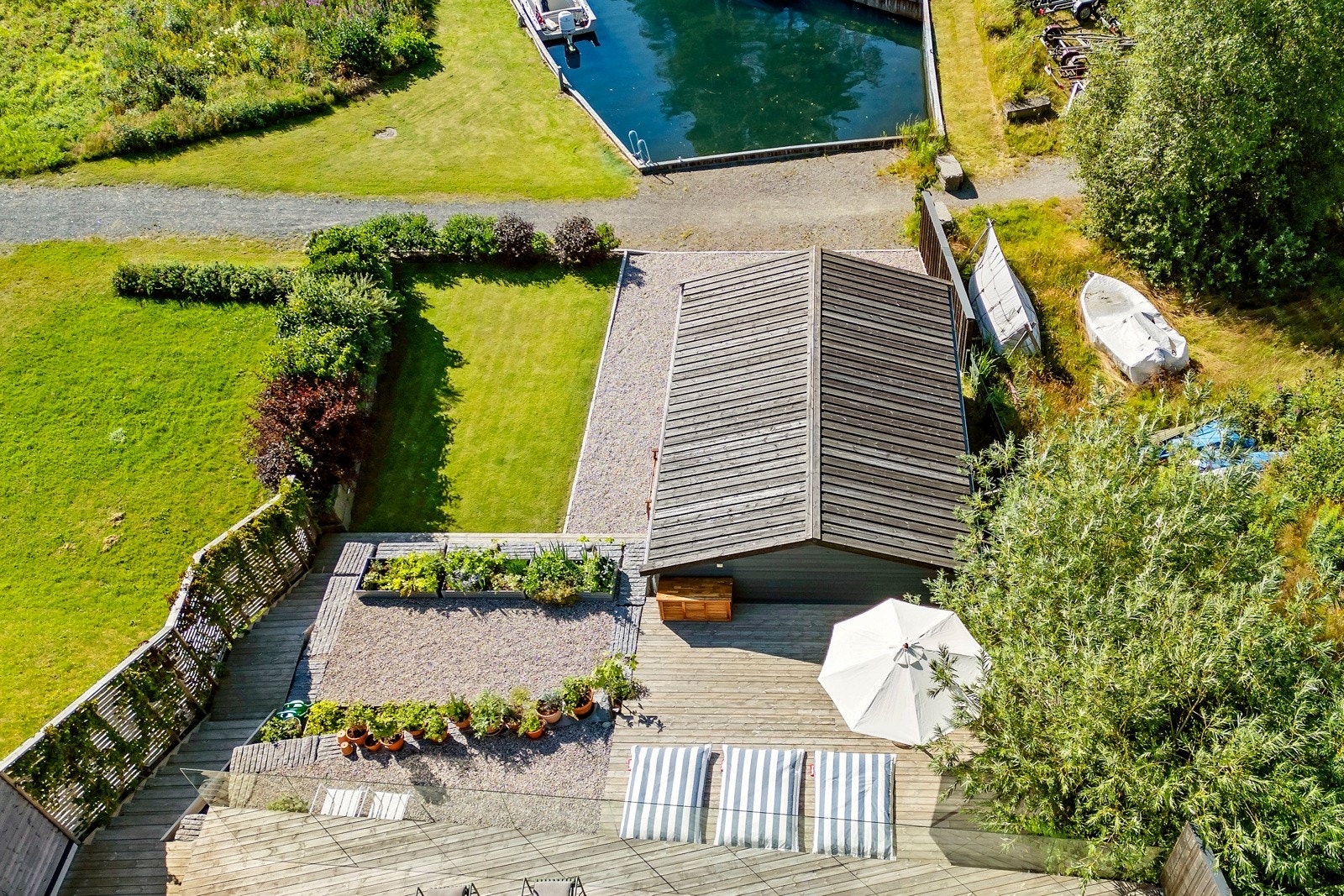 Vestvendt idyll med terrasser, båthus, egen havn og kanal Galleribilde