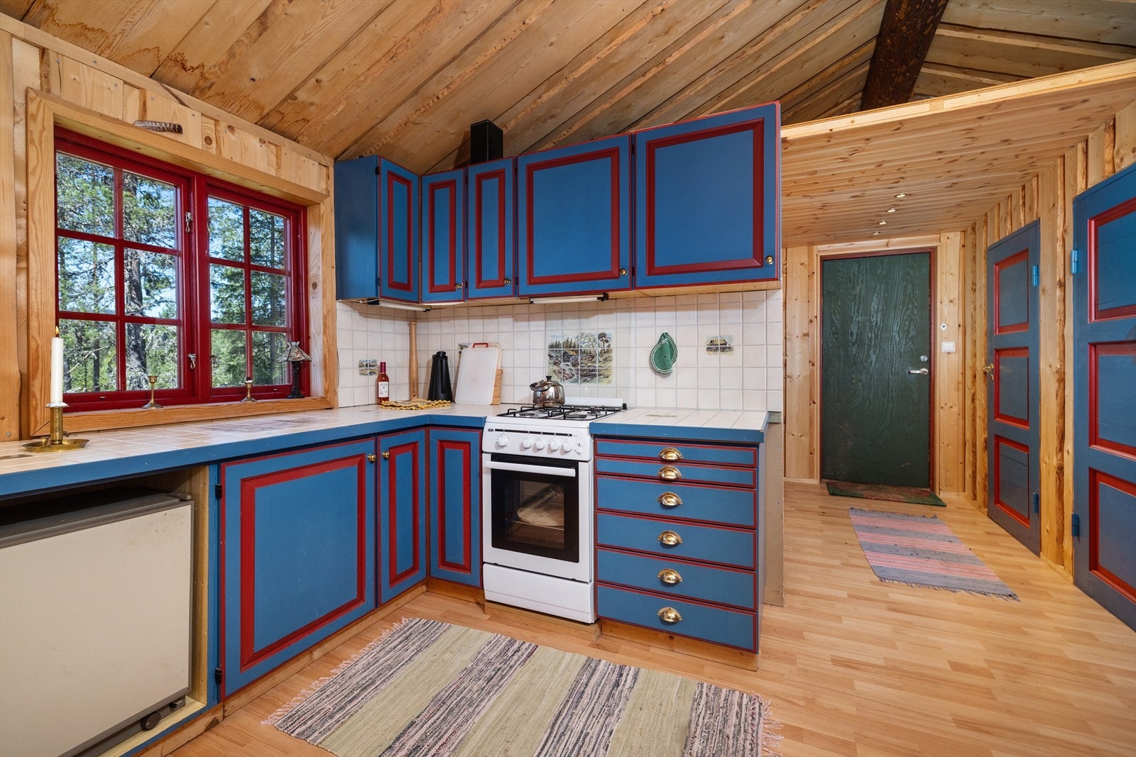 Kjøkkeninnredningen er av eldre type, trolig fra 1980-tallet, med profilerte fronter og flislagt benkeplate. Galleribilde