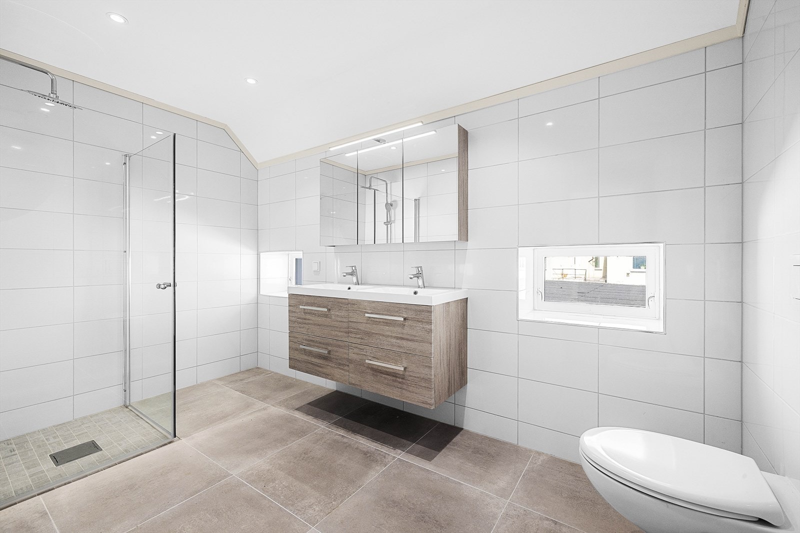 Baderom II er romslig med tidsriktige flislagte vegger og gulv, med varmekabler Galleribilde