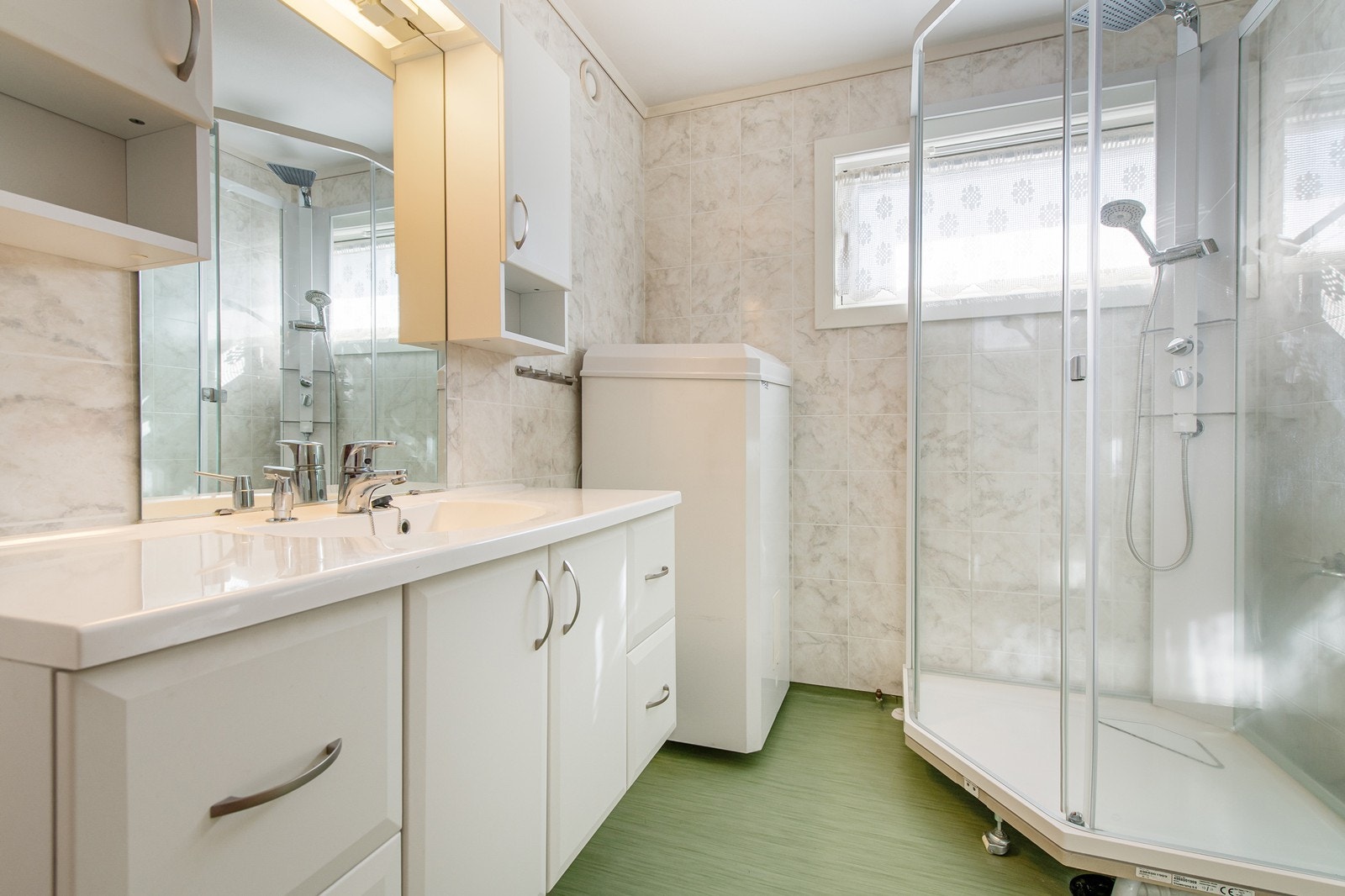 Enkelt bad med lukket dusjkabinett og vaskeservant i innredning. Galleribilde