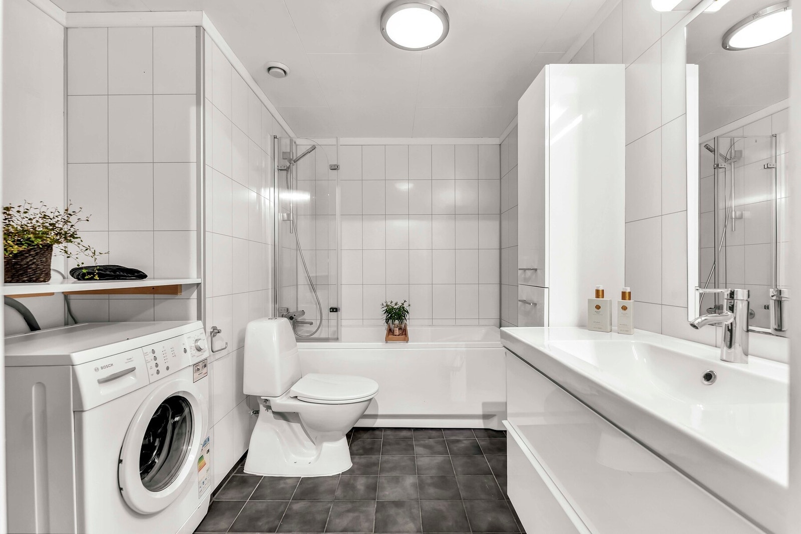 Pent og praktisk bad med badekar, wc, servant og opplegg for vaskemaskin. Galleribilde