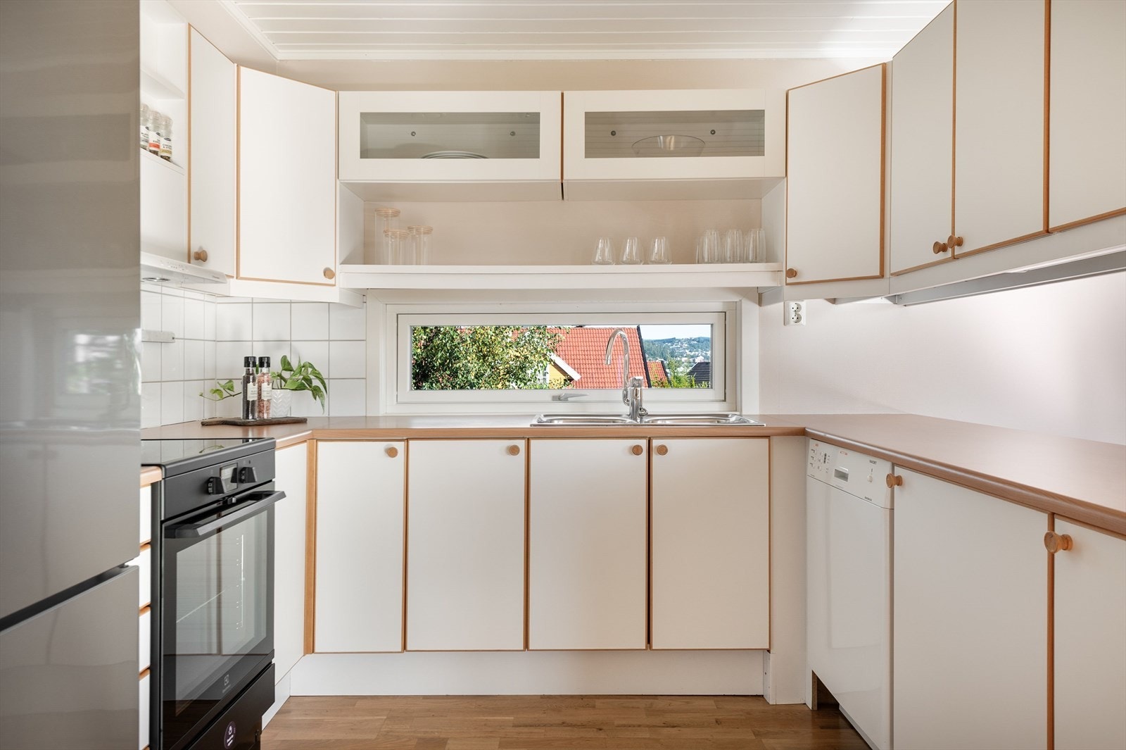 Lyst og anvendelig kjøkken som har godt med skap og benkeplass. Galleribilde