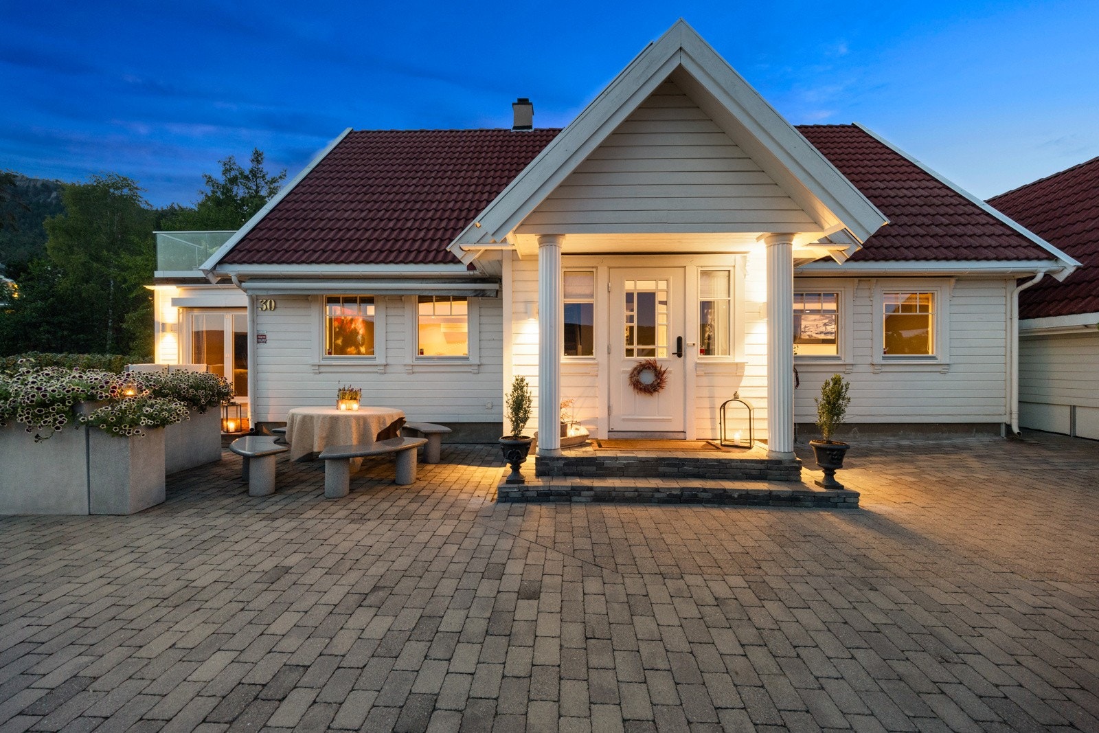Innbydende inngangsparti med takoverbygg, søyler og utebelysning. Et flott førsteinntrykk. Galleribilde