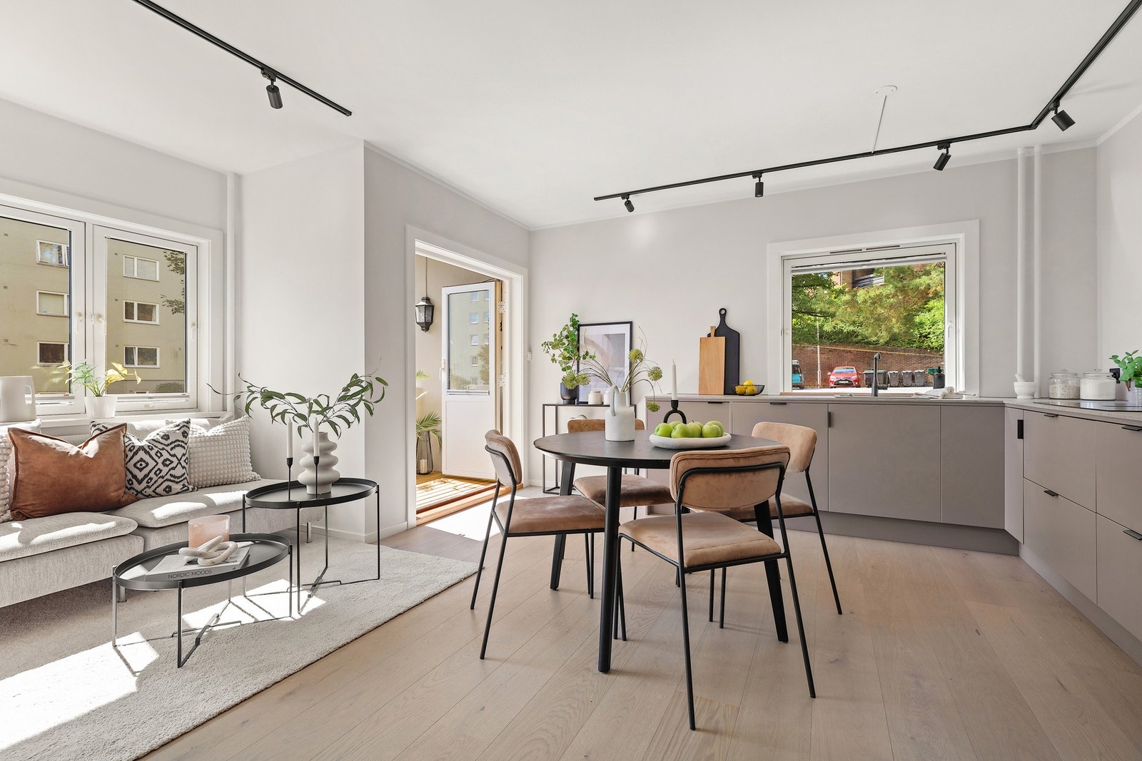 Lys og moderne stue med store vindusflater og åpen løsning mot kjøkkenet. Galleribilde