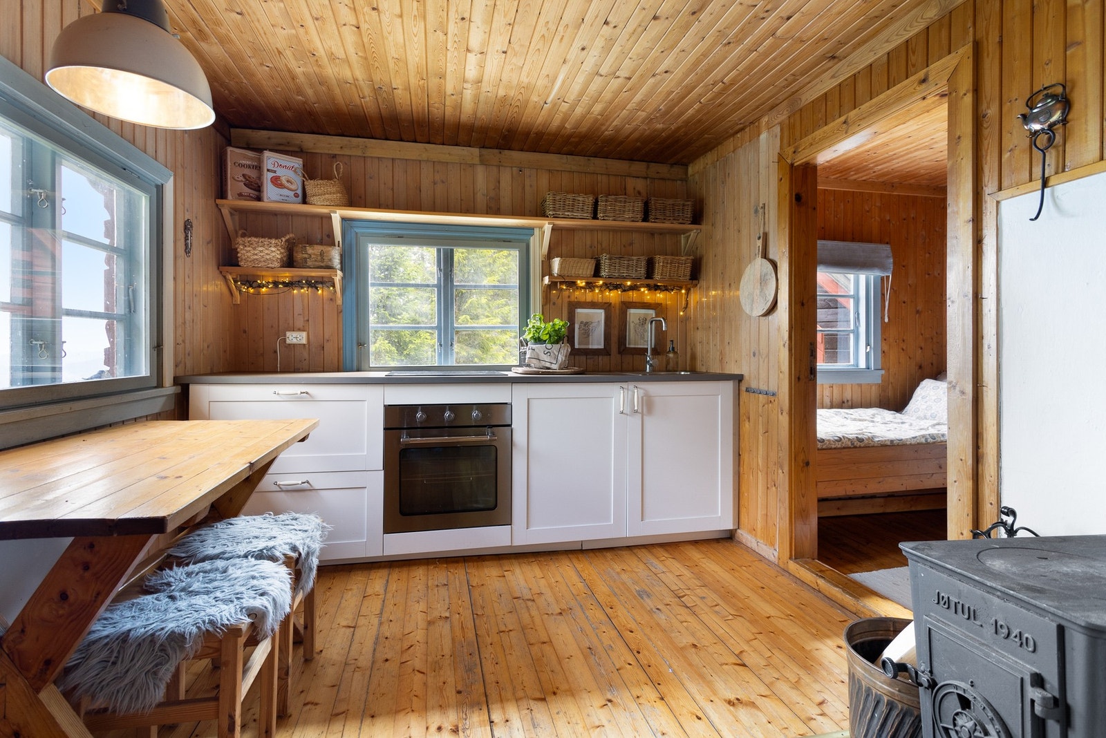 Lyst og trivelig kjøkken. Kjøkkenet inneholder vask, kjøleskap, stekeovn og platetopp. Fin løsning med åpne hyller over kjøkkenbenk Galleribilde