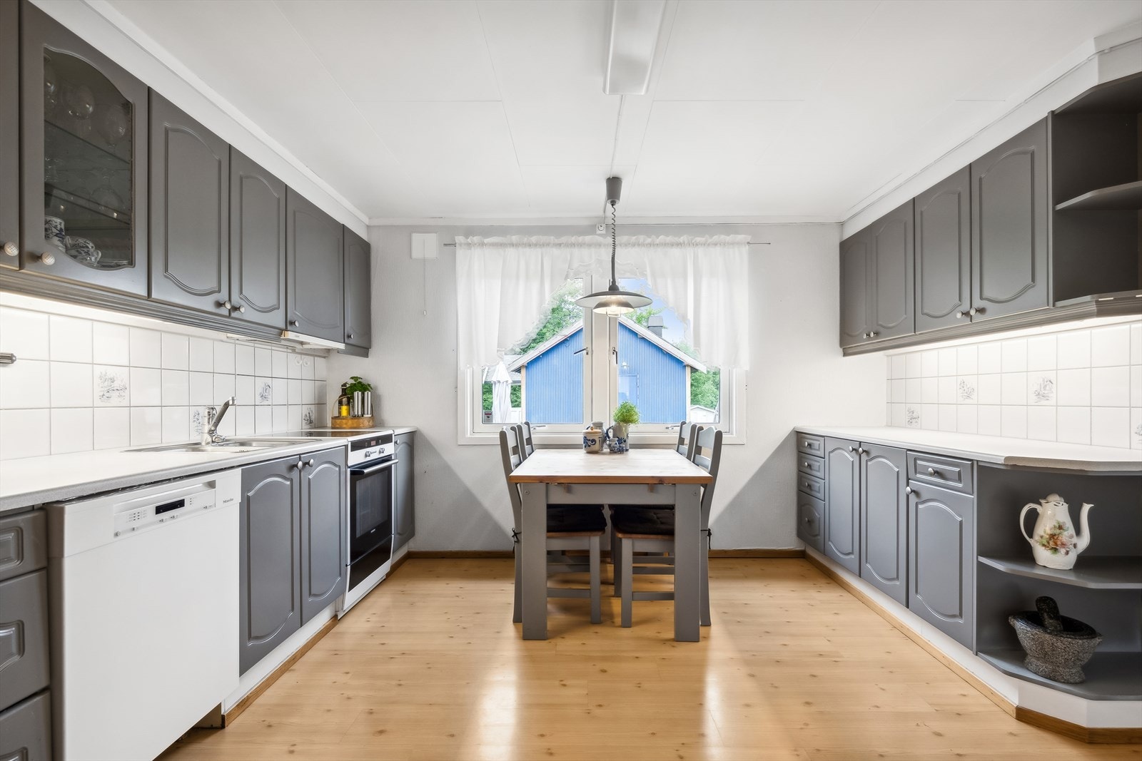 Romslig kjøkken med rom for spiseplass ved kjøkkenvinduet. Galleribilde