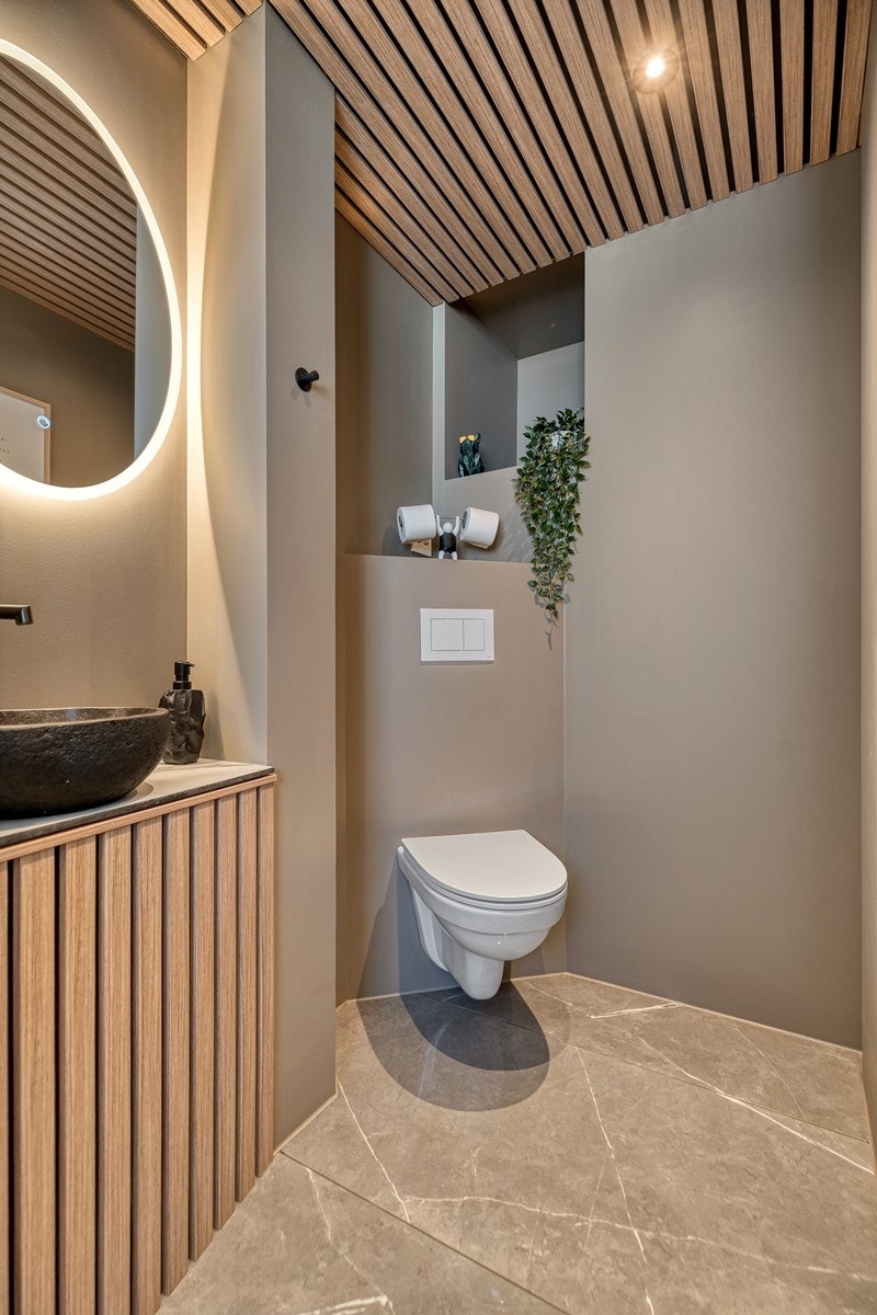 Toalettet har varmekabler i gulv samt flotte fliser. Det er vegghengt toalett og spiler i tak med downlights som skaper en fin kontrast. Galleribilde