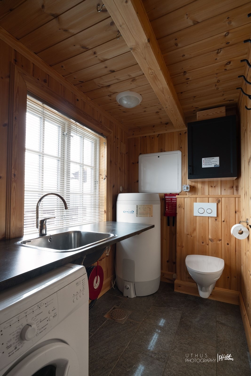 Hytten har et praktisk vaskerom kombinert med gjestetoalett. Her finner man opplegg for vaskemaskin og kondenstørketrommel, i tillegg til utslagsvask og en praktisk benkeplate som gjør rommet funksjonelt og brukervennlig. Galleribilde