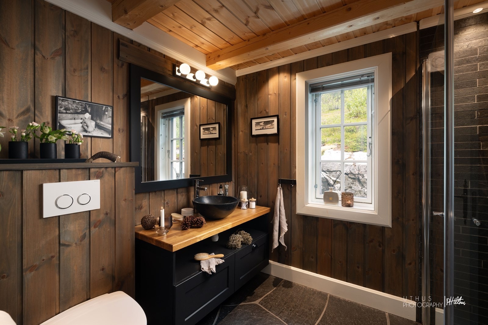 Baderommet er lekkert utført med skifergulv med varme, samt fliser på vegg i dusjsonen. Den plassbygde baderomsinnredningen med heltre benkeplate i eik gir rommet et eksklusivt og tidløst uttrykk. Galleribilde