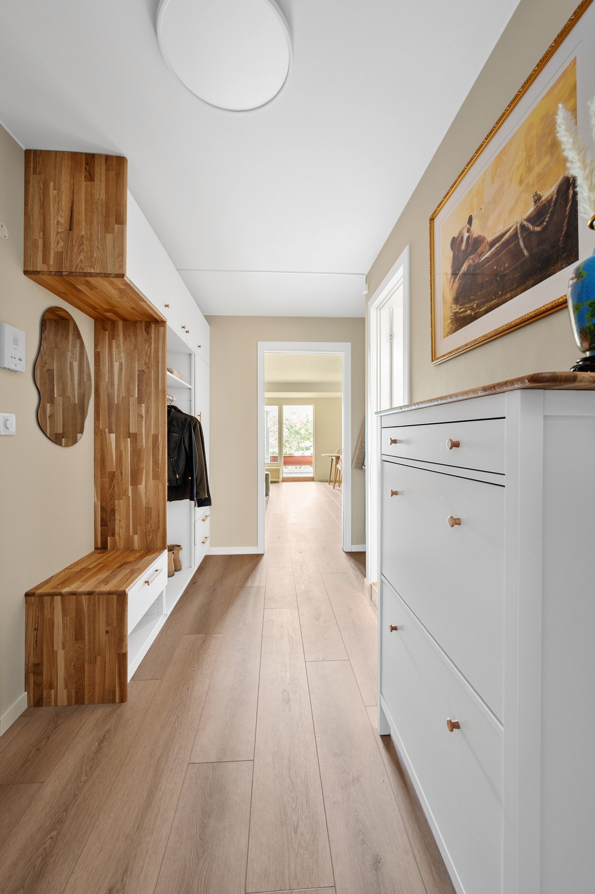 Romslig utbygget entré med plassbygde garderobeløsninger og skyvedør til stue. Gangen er malt i fargen Vanilje fra Jotun som skaper en lys og innbydende atmosfære. Galleribilde