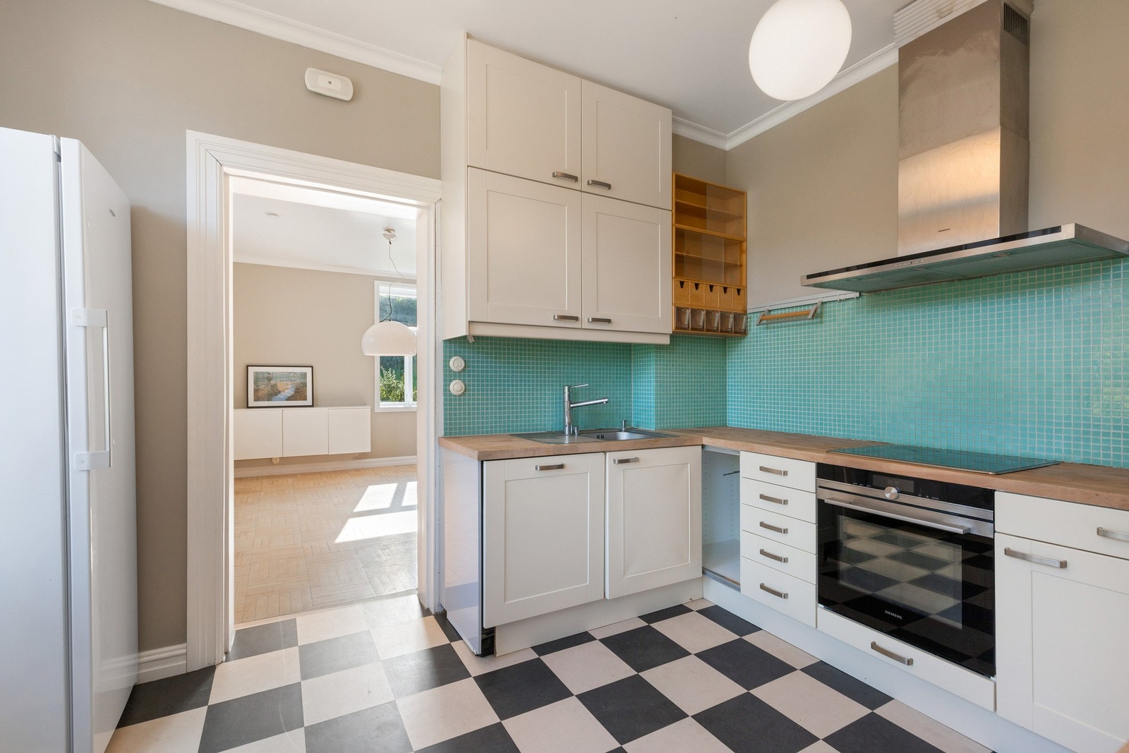 Det er montert mosaikk fliser på vegg over benkeplaten. Galleribilde