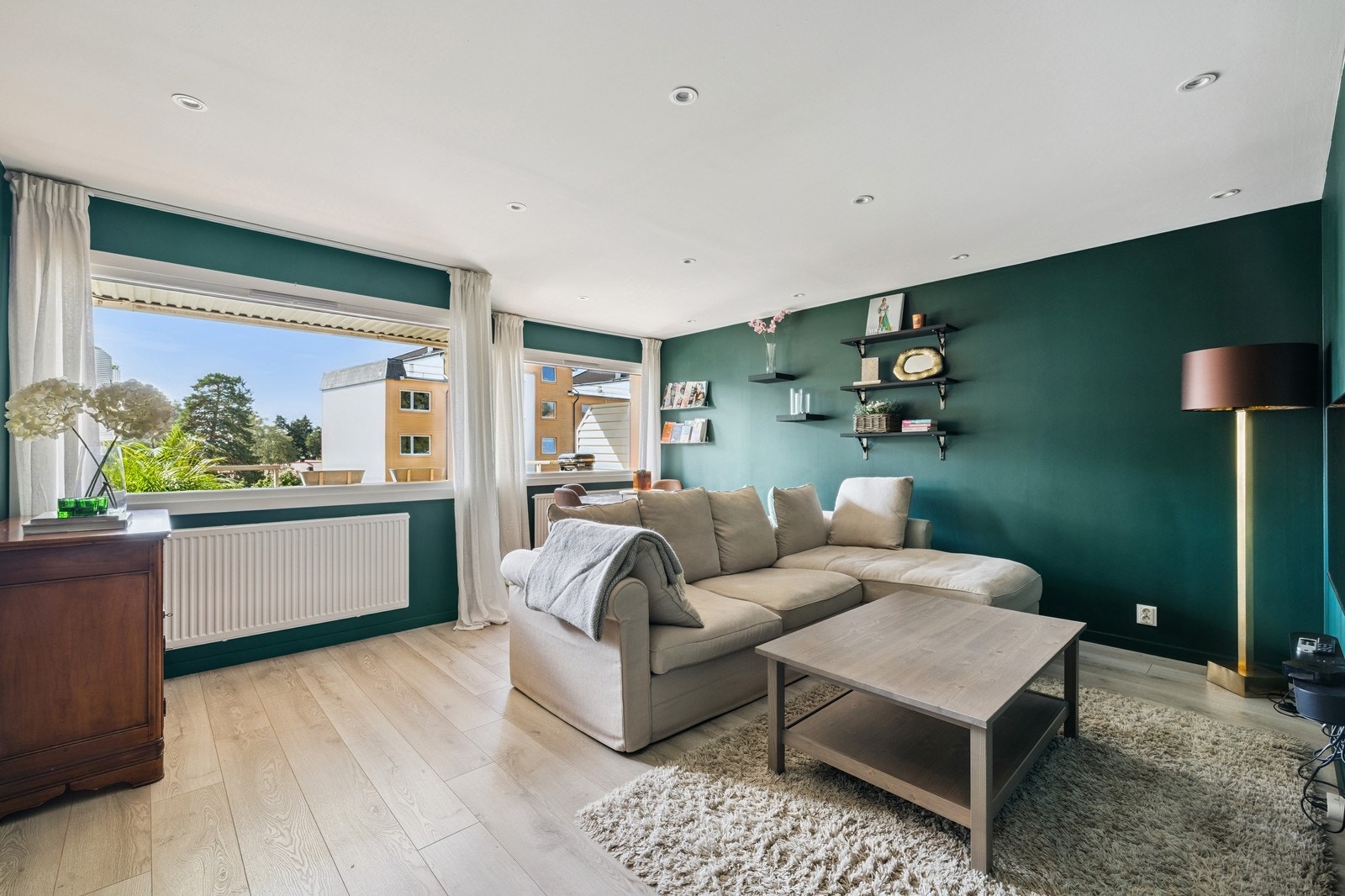 Romslig stue med stor sofagruppe. Fra stuen har man utgang til balkong. Galleribilde