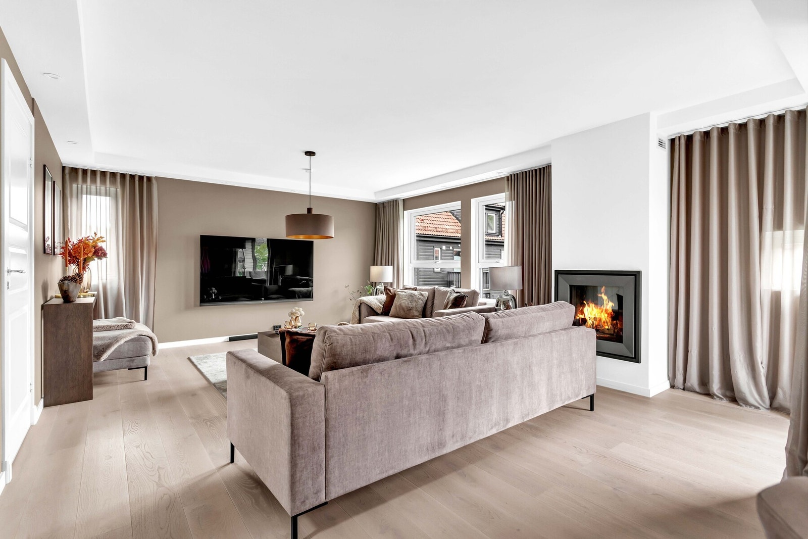 De store vindusflatene gir både rikelig lys og et hyggelig utsyn mot nærområdet, samtidig som gardinene gir en eksklusiv følelse. Galleribilde