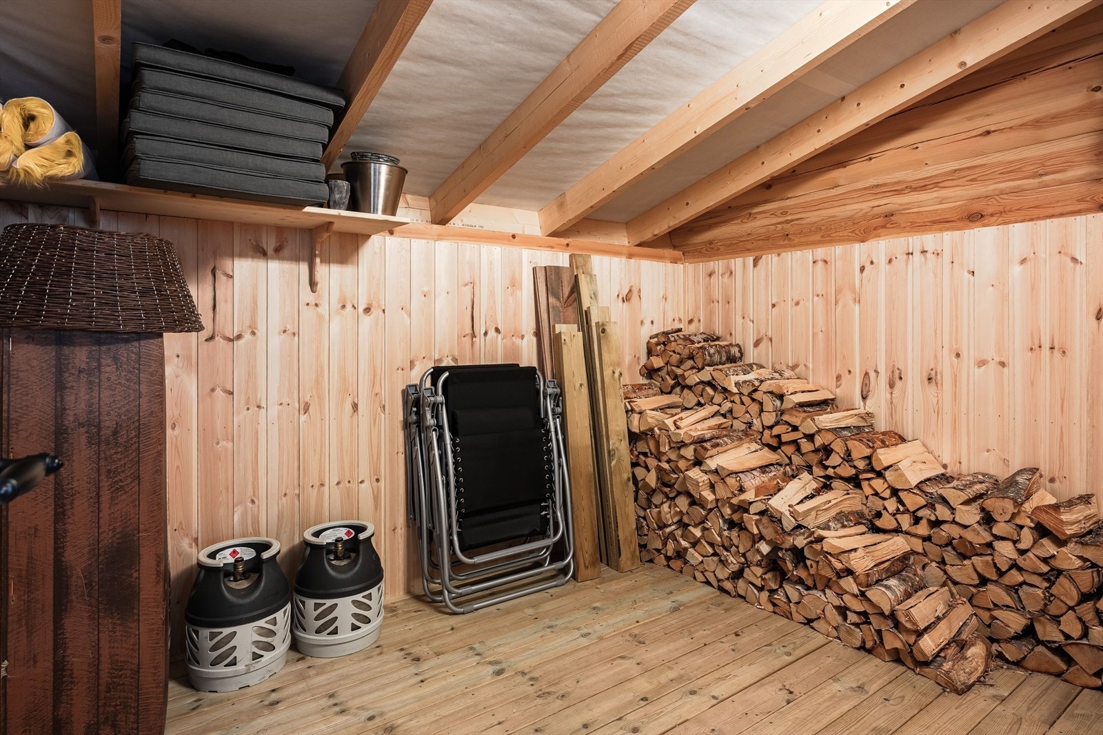 Rett utenfor terrassedøren ved stuen finner man uteboden, som har god plass til lagring av f.eks. utemøbler og ved. Praktisk å kunne gå tørrskodd for å hente ved. Galleribilde