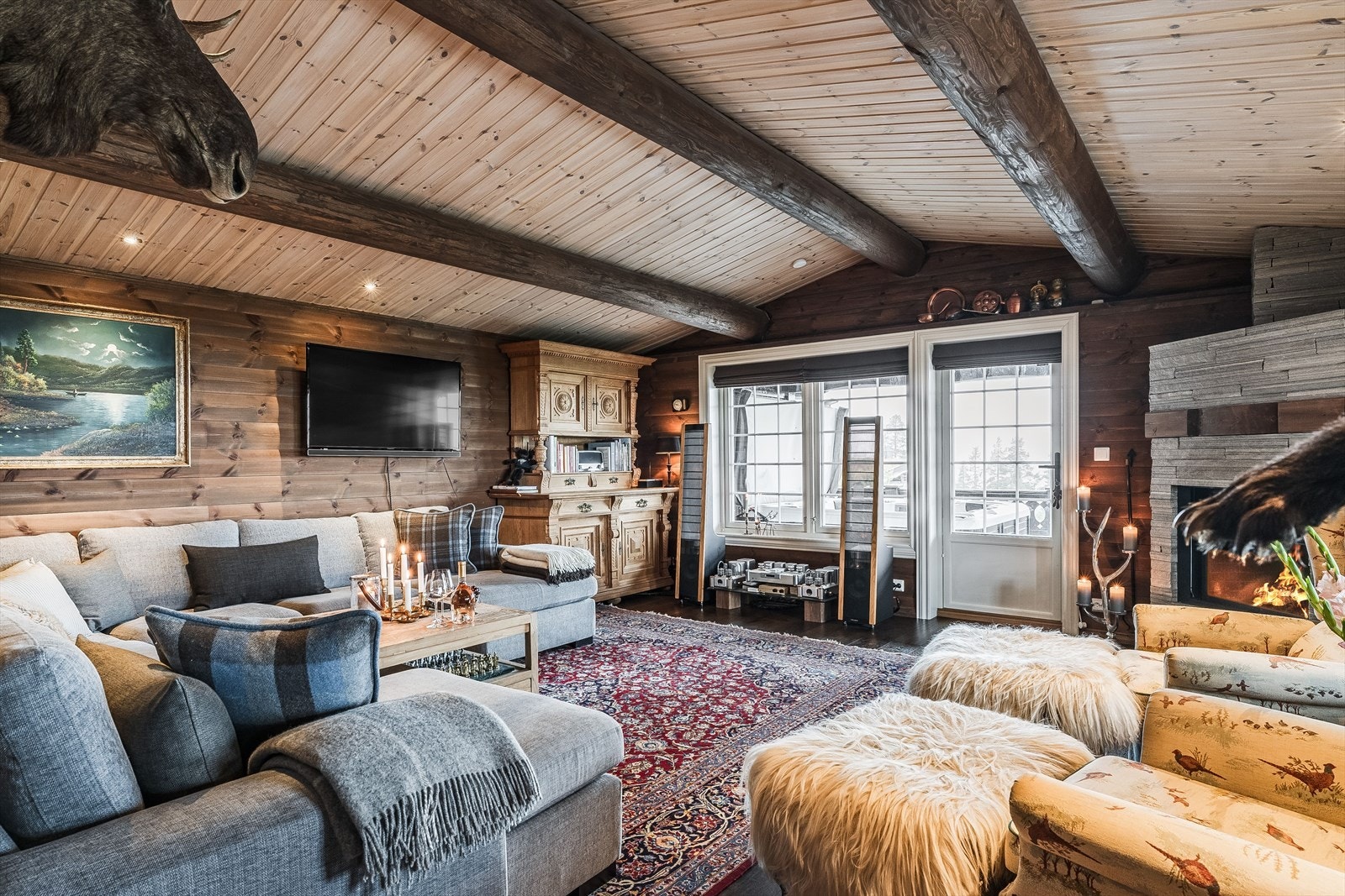 Fra kjøkkenet og spisestuen er det åpen løsning inn til den åpne og luftige, men likevel lune stuen. Stuen har god plass til sittemøbler, og har gjennomgående og gode farge- og materialvalg som hytta forøvrig. Legg merke til at det også her er downlights. Galleribilde