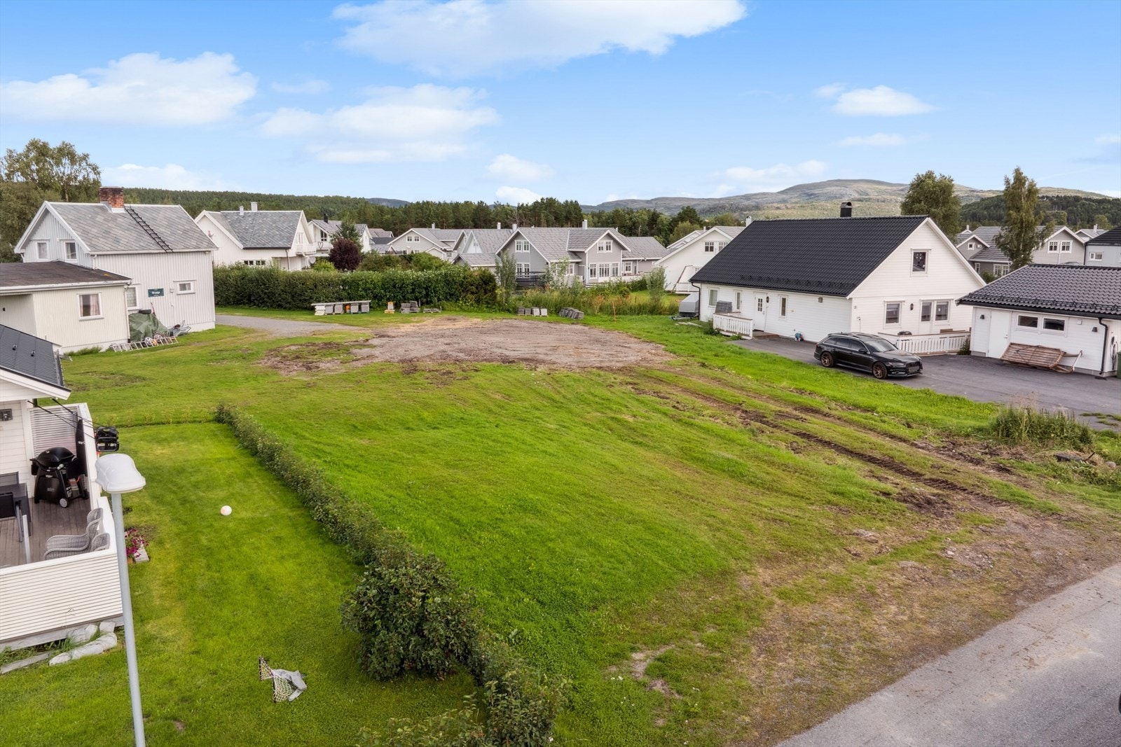 Tomten er flat og opparbeidet med plen. Galleribilde