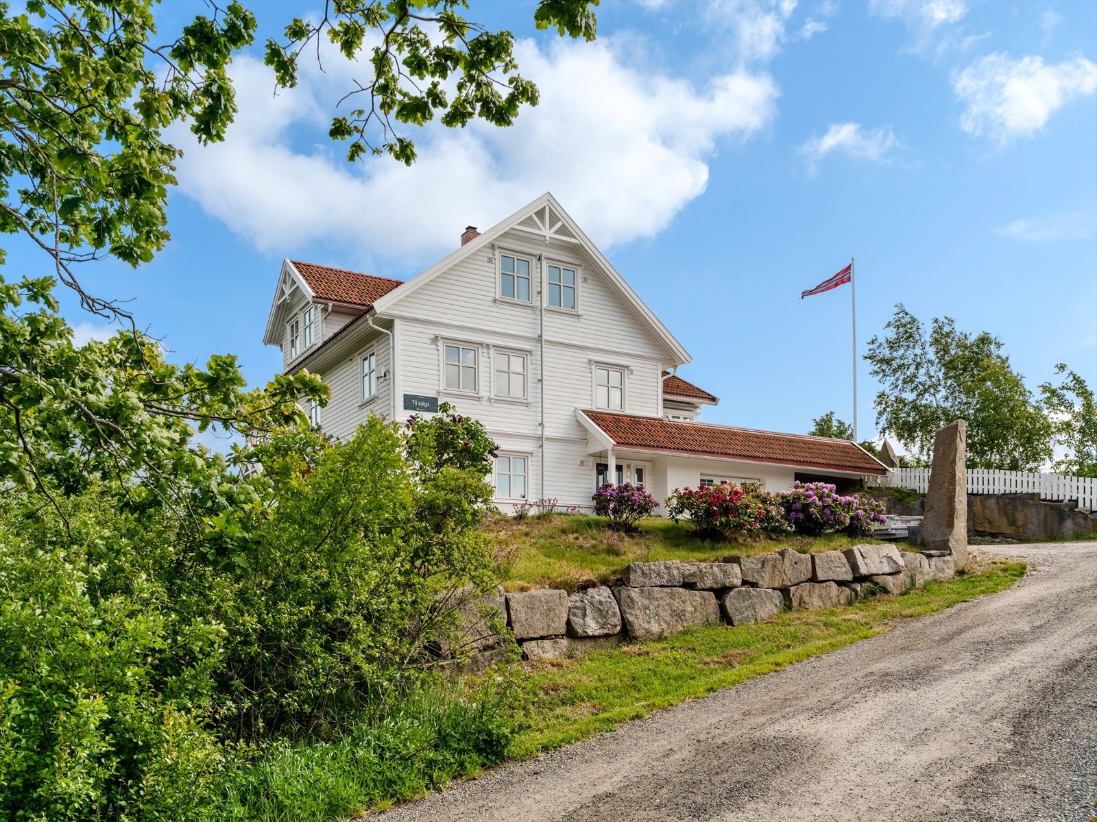 Adkomst til boligen via gruset blindvei med lite trafikk. Eiendommen ruver praktfullt i terrenget. Galleribilde