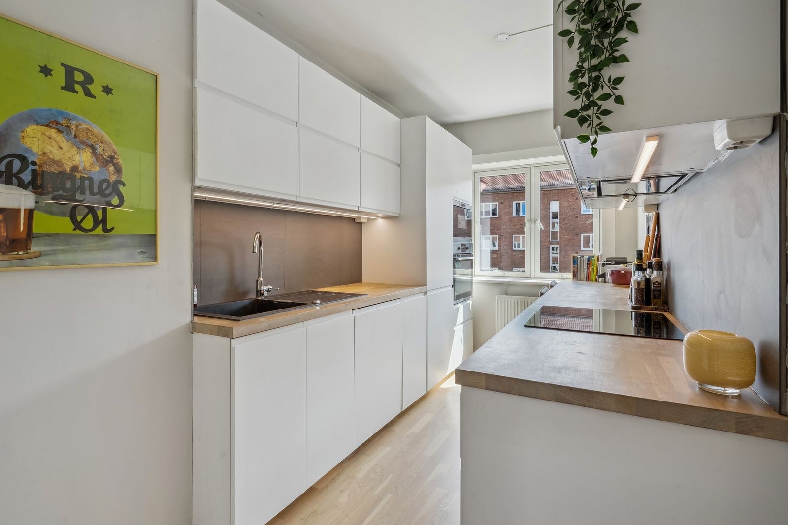 Adskilt og pent kjøkken med integrerte hvitevarer og moderne innredning. Galleribilde