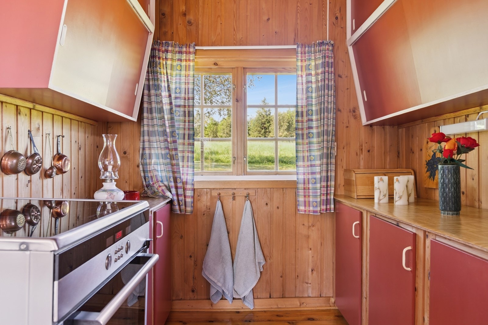 Enkel eldre kjøkkeninnredning med plass til komfyr og kjørleskap. Galleribilde