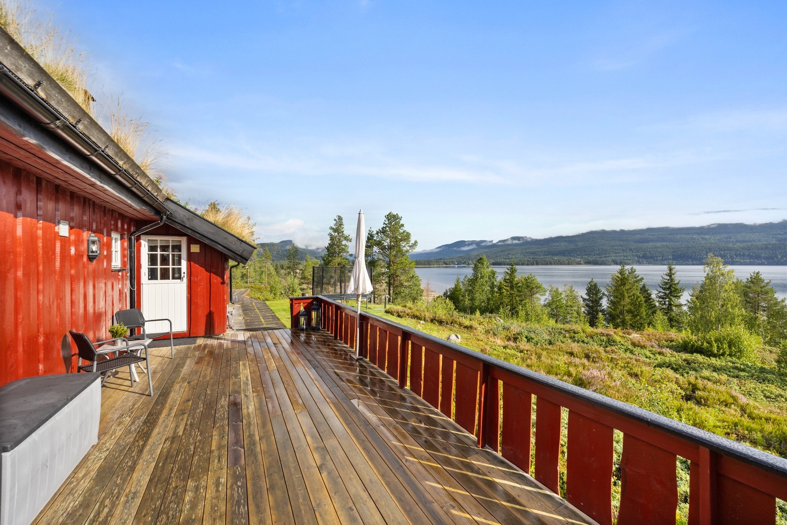 Hytten har en terrasse som strekker seg rundt store deler av boligen Galleribilde