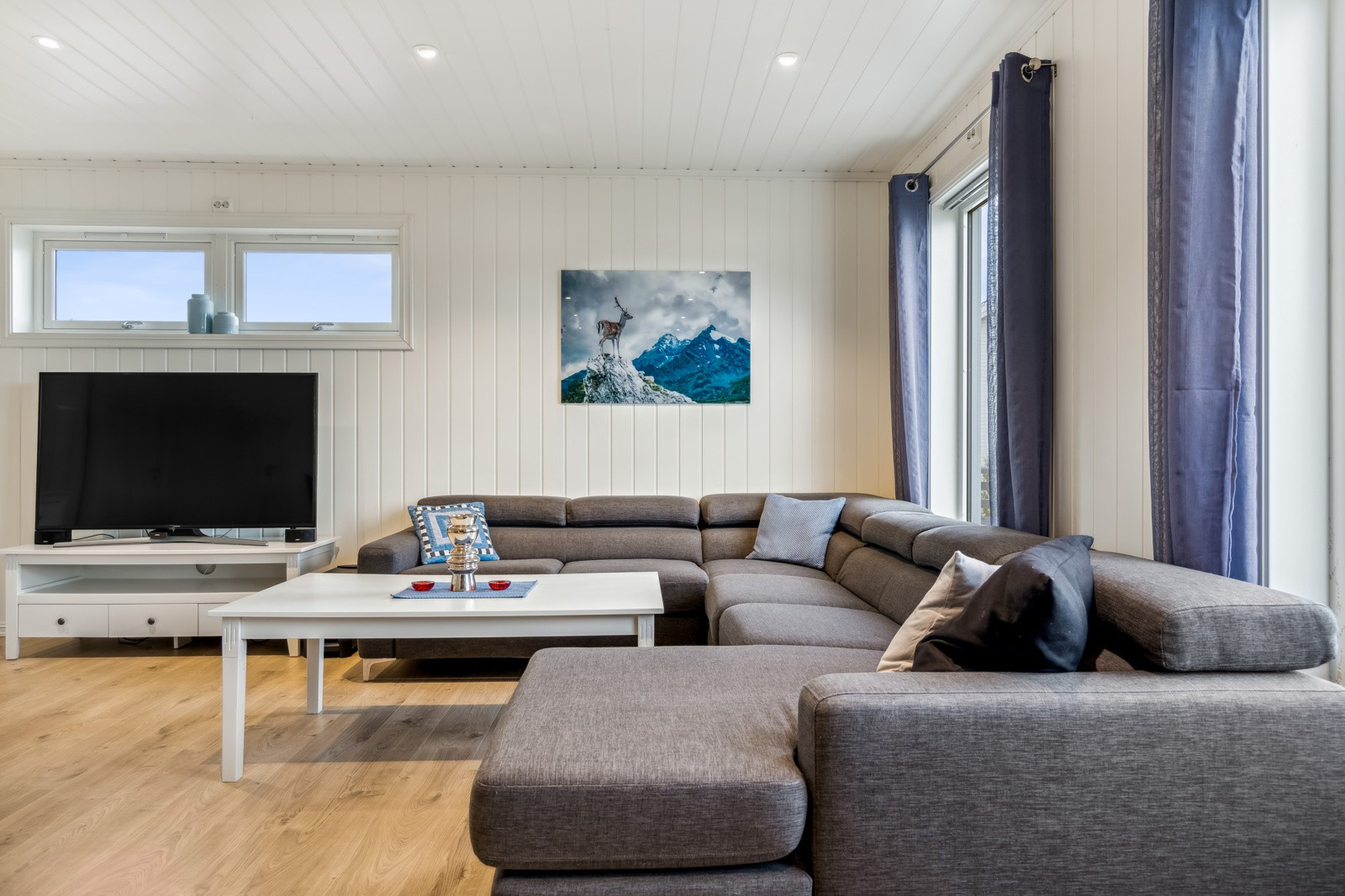 Romslig stue med flere naturlige soner for innredning av både sofagruppen og spisebordet.