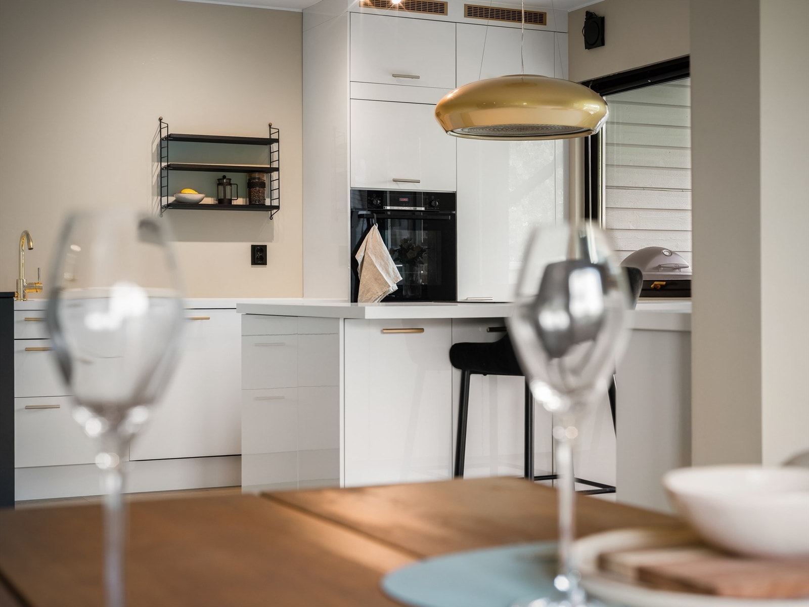 Med platetoppen integrert i kjøkkenets halvøy står du orientert mot både barløsningen og stuen under tilberedning. Galleribilde