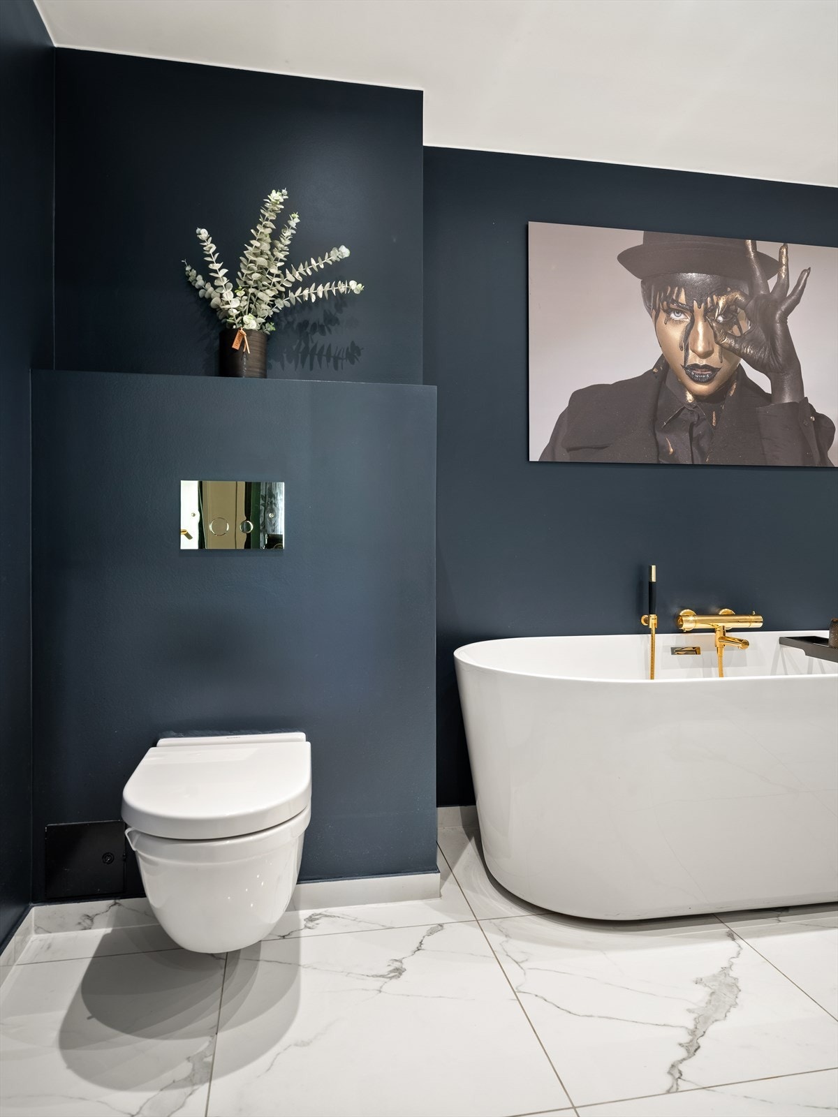 Armaturene på badet er alle i messing, en gyllen kontrast til de hvite og blåmalte overflatene. Galleribilde