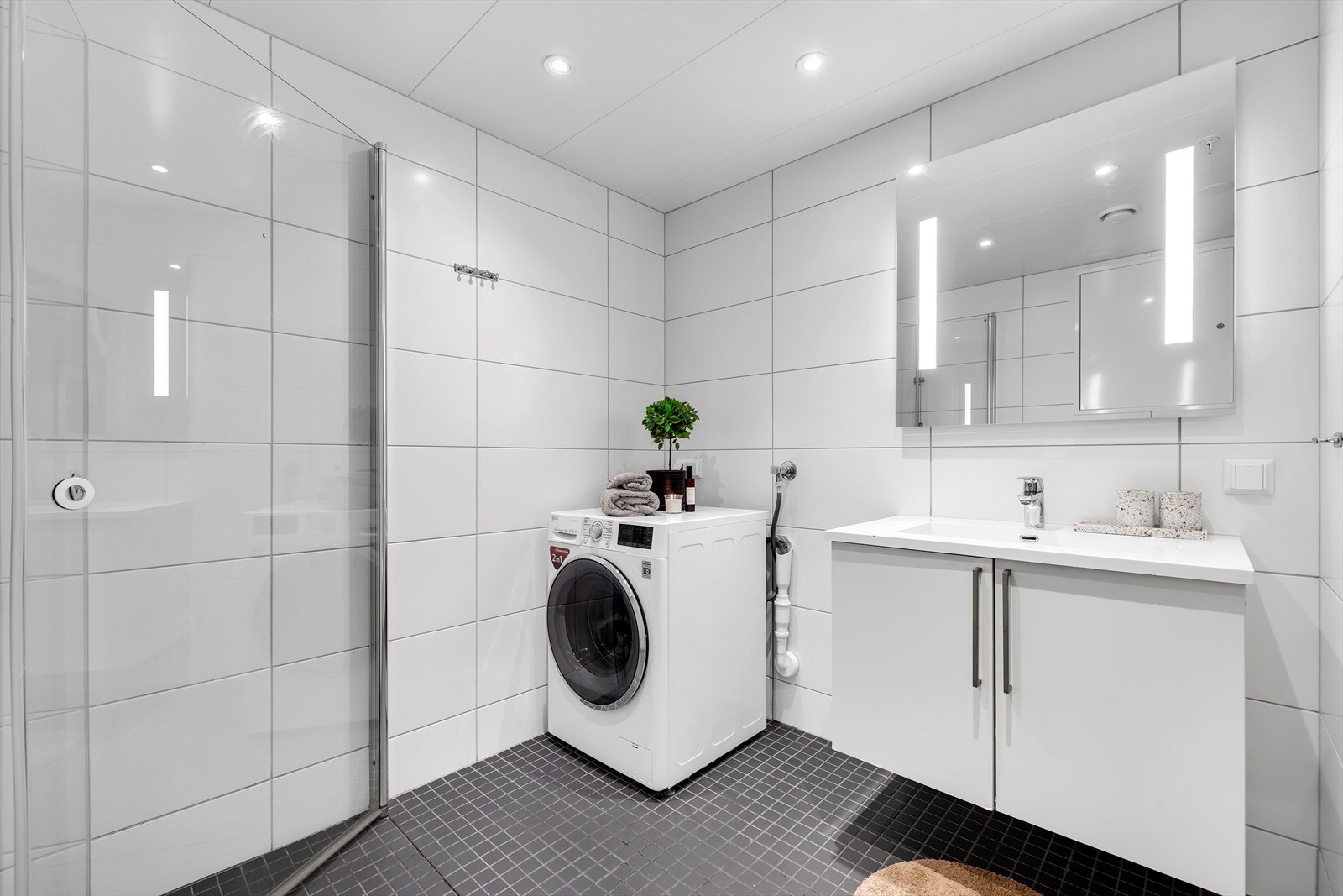 Badet har innredning med nedfelt servant i skap, veggmontert toalett,
dusjhjørne og opplegg for vaskemaskin. Her har alle punkter fått tilstandsgrad 1 i rapport fra takstmannen. Galleribilde