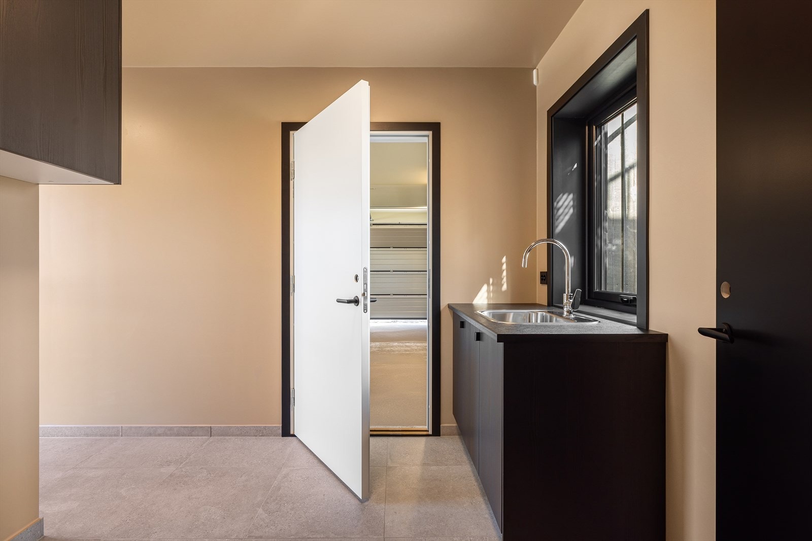 Her finner du funksjonell innredning med nedfelt skyllekar, ettgreps blandebatteri samt opplegg for både vaskemaskin og tørketrommel. Galleribilde