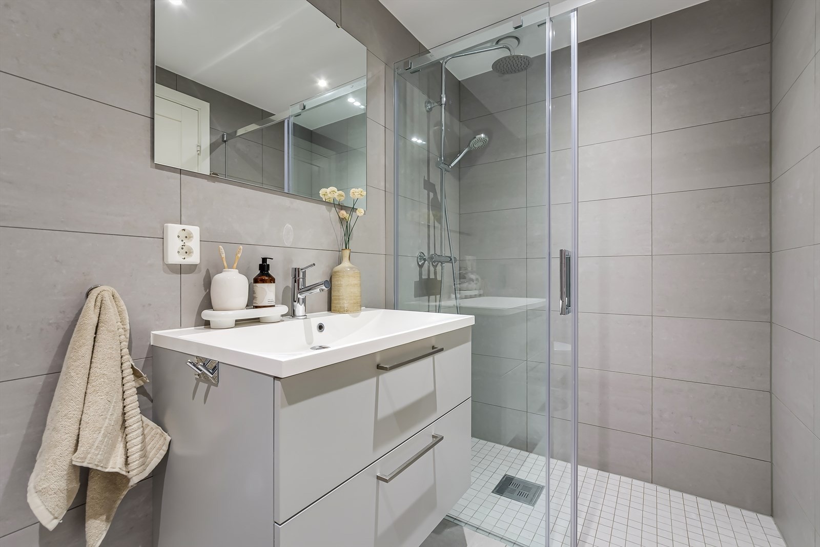Fra entréen ligger det et bad | Badet er flislagt med store fliser på vegger og gulv, som gir et moderne uttrykk. Galleribilde