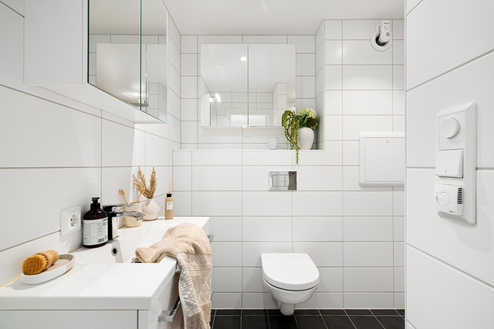 Flott nyere og helfliset baderom med dusjnisje, vegghengt toalett og servant. Varmekabler i gulv. Galleribilde