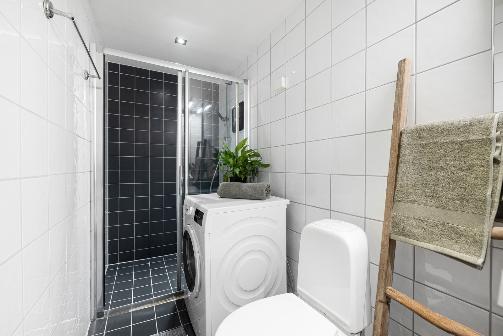 Badet er stilrent og praktisk utformet, med mørke gulvfliser og varmekabler som gir en behagelig komfort. Galleribilde