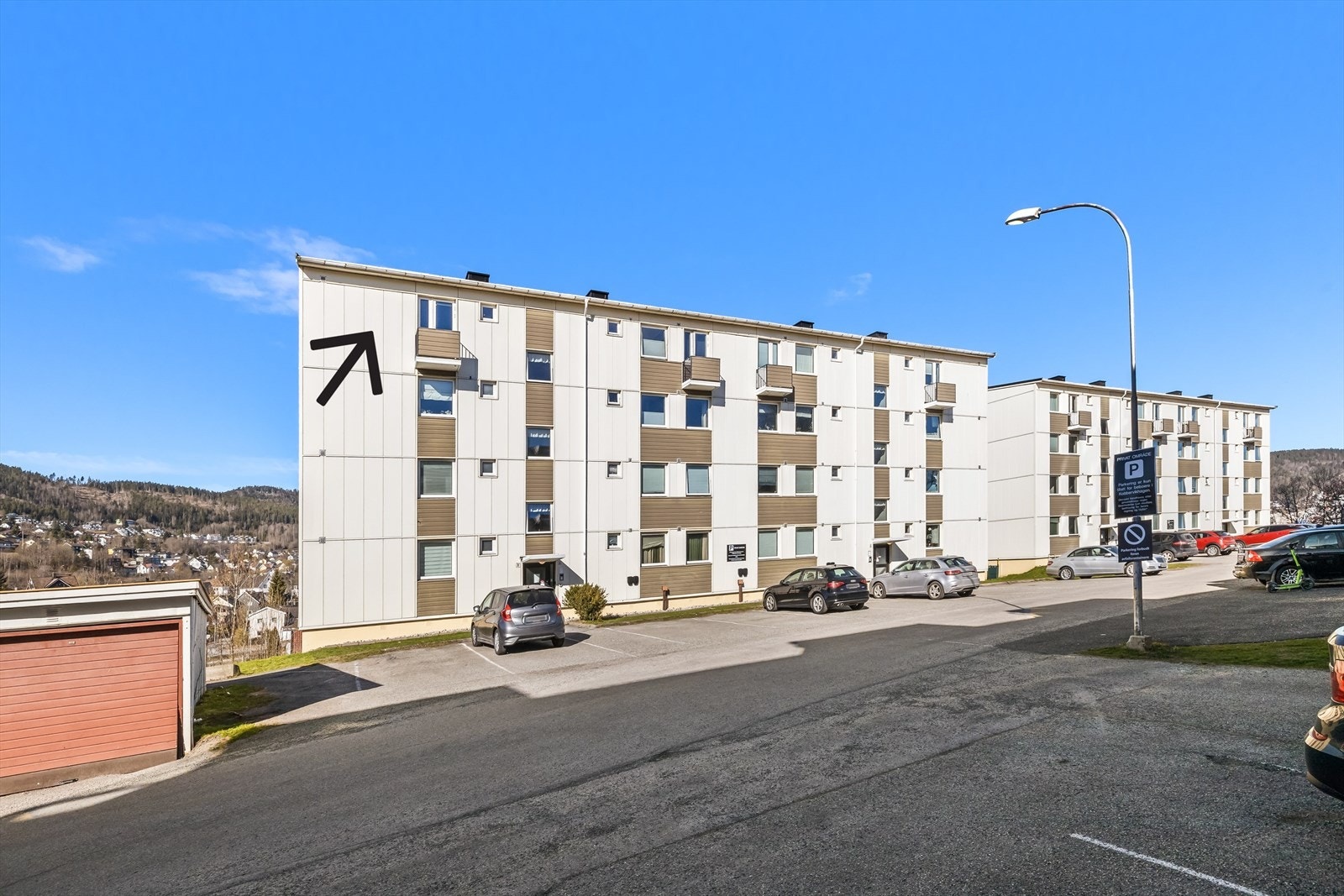 Fasade og inngangsparti med parkeringsplass. Galleribilde