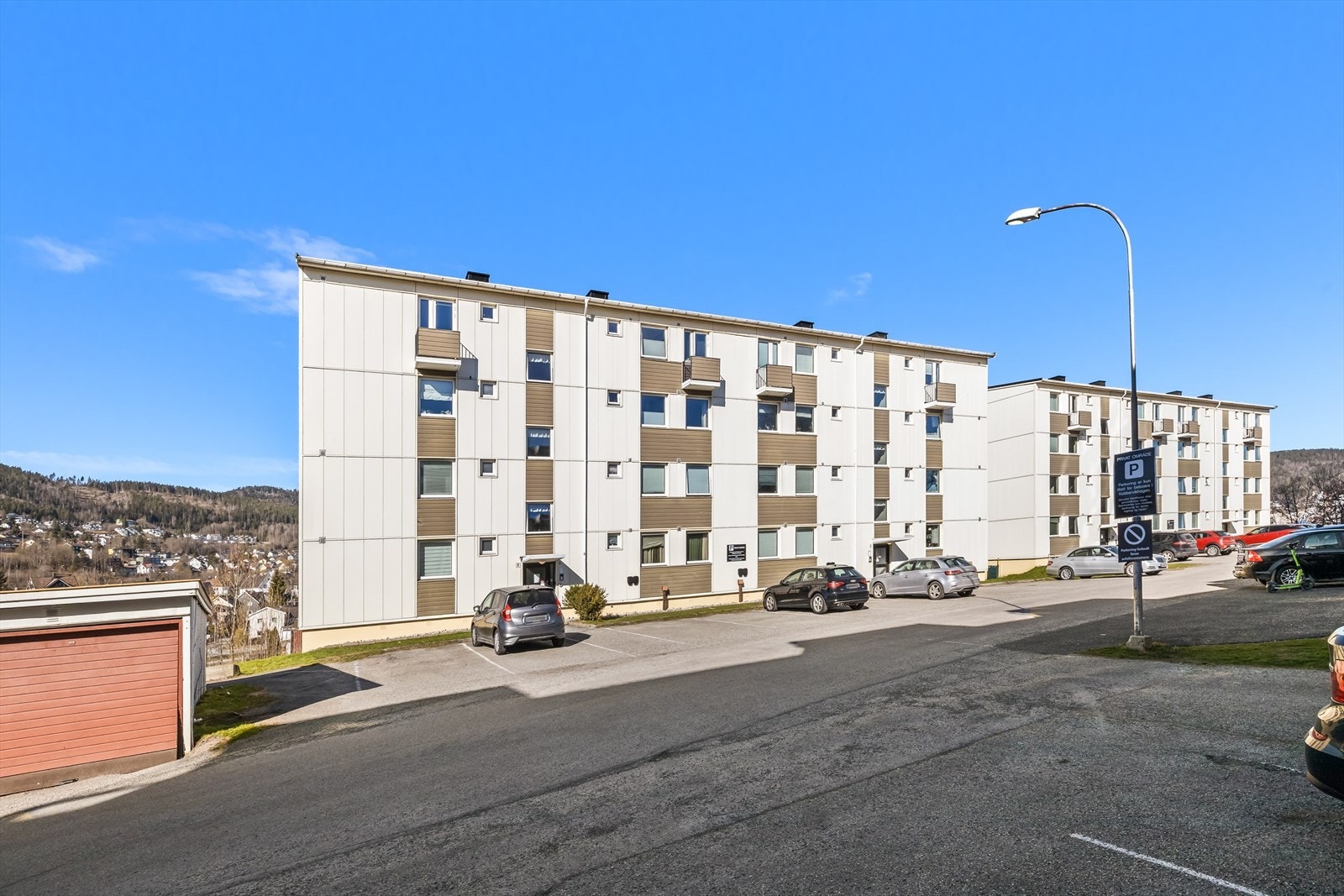 Fasade og inngangsparti med parkeringsplass. Galleribilde