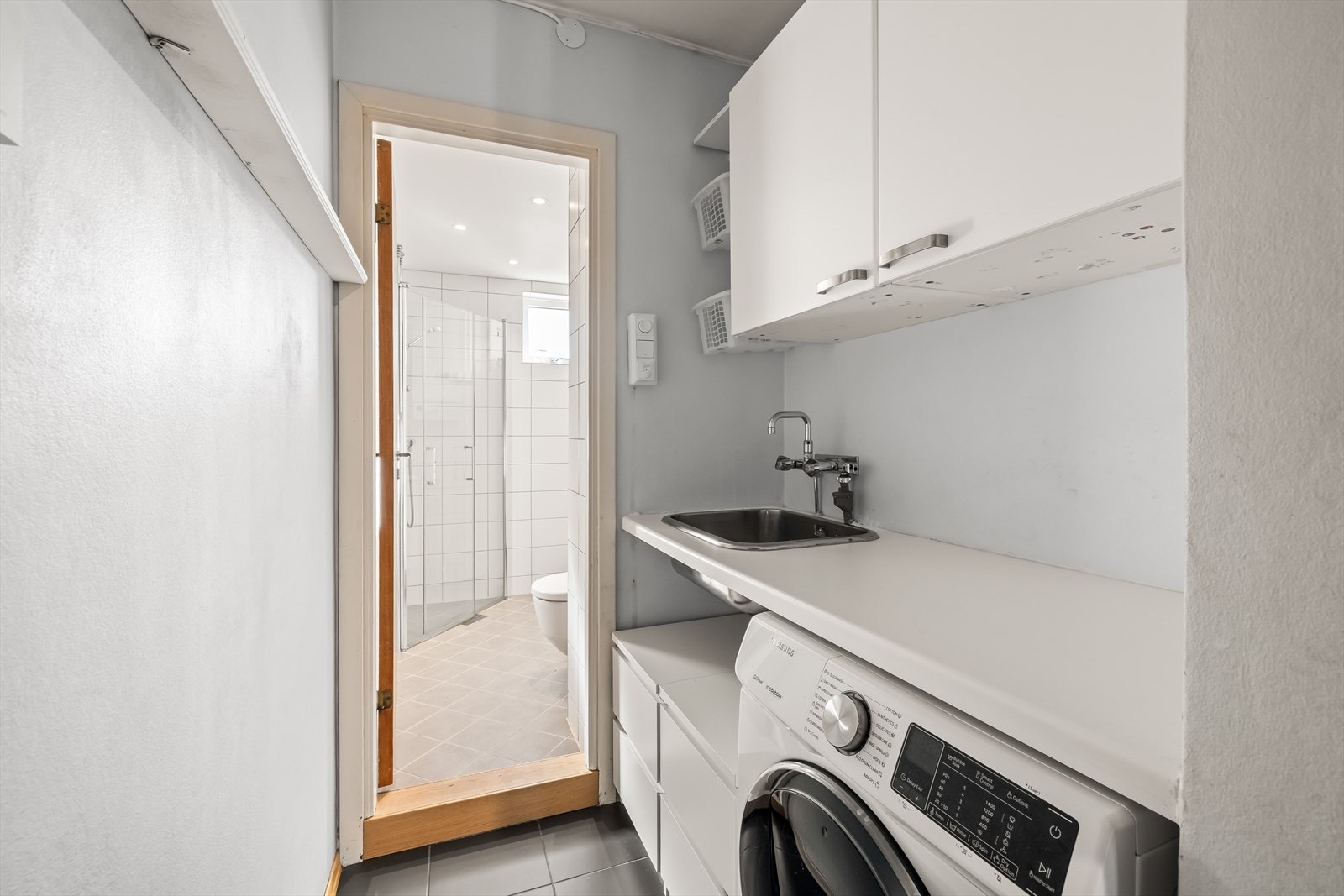 Moderne baderomsinnredning med opplegg for vaskemaskin. Galleribilde