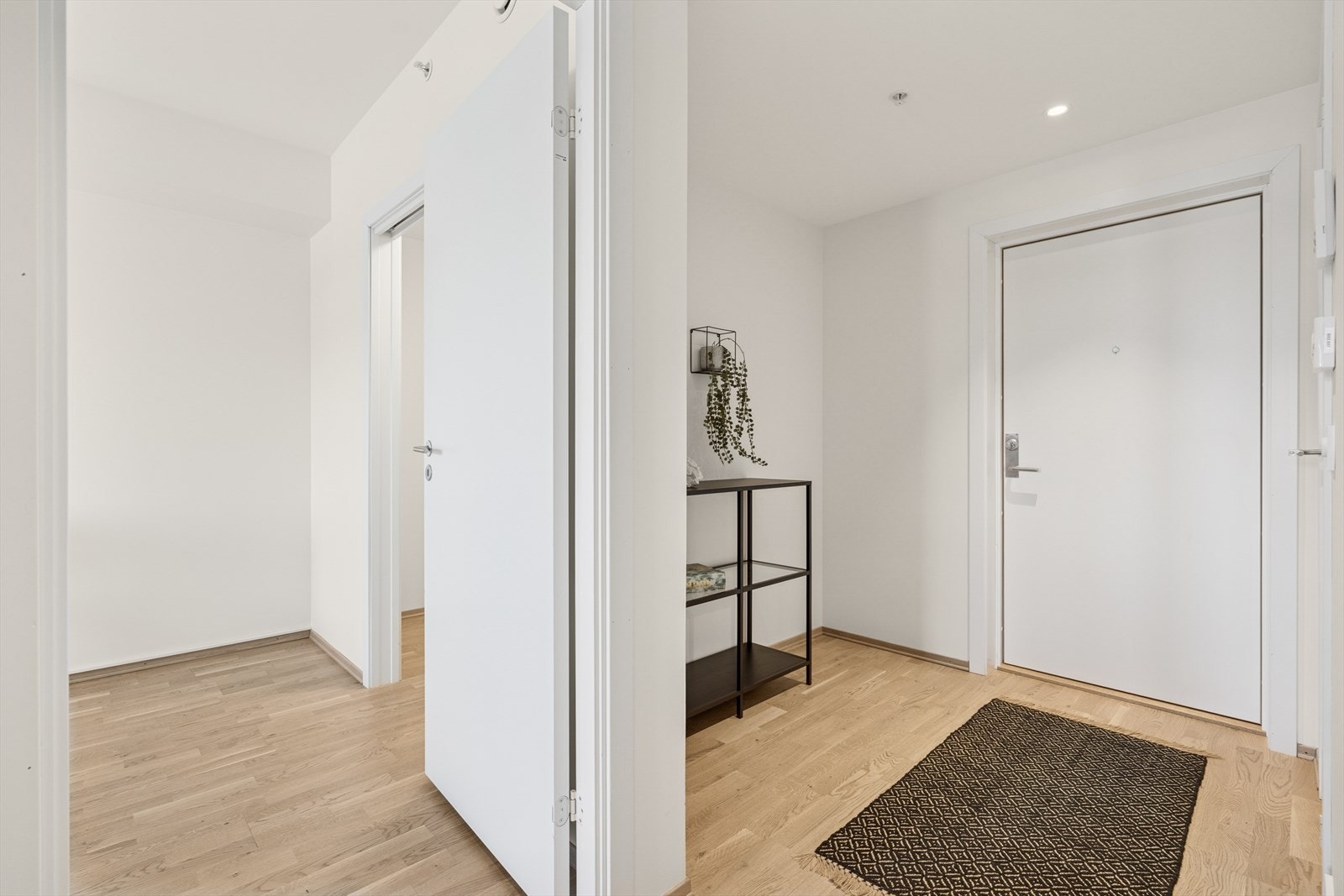 En lysmalt entré ønsker deg velkommen inn i leiligheten. Galleribilde